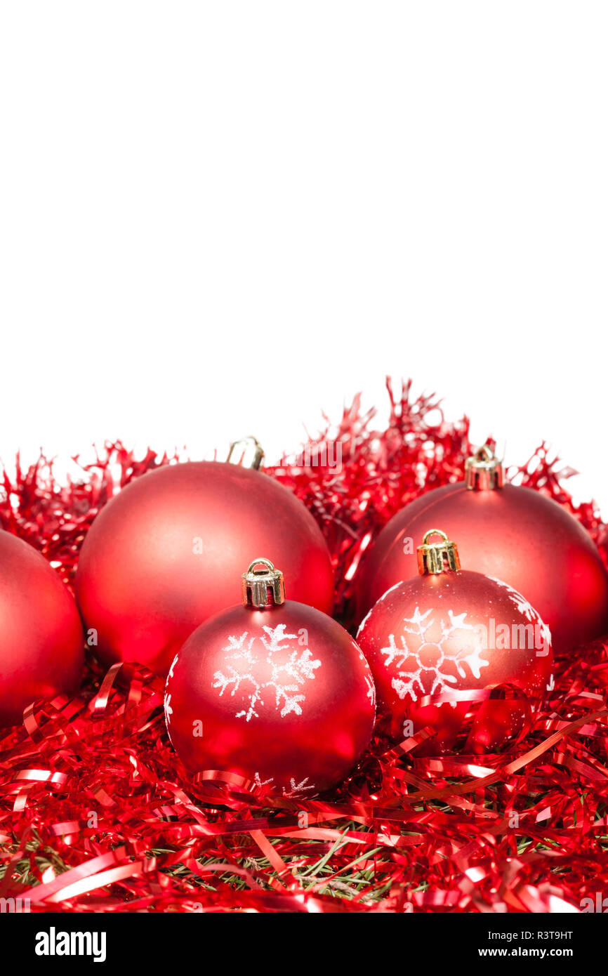 Fünf rote Weihnachtskugeln und Lametta isoliert Stockfoto