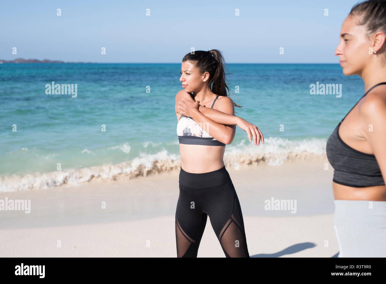 Spanien, Kanarische Inseln, Fuerteventura, zwei junge Frauen trainieren am Strand Stockfoto