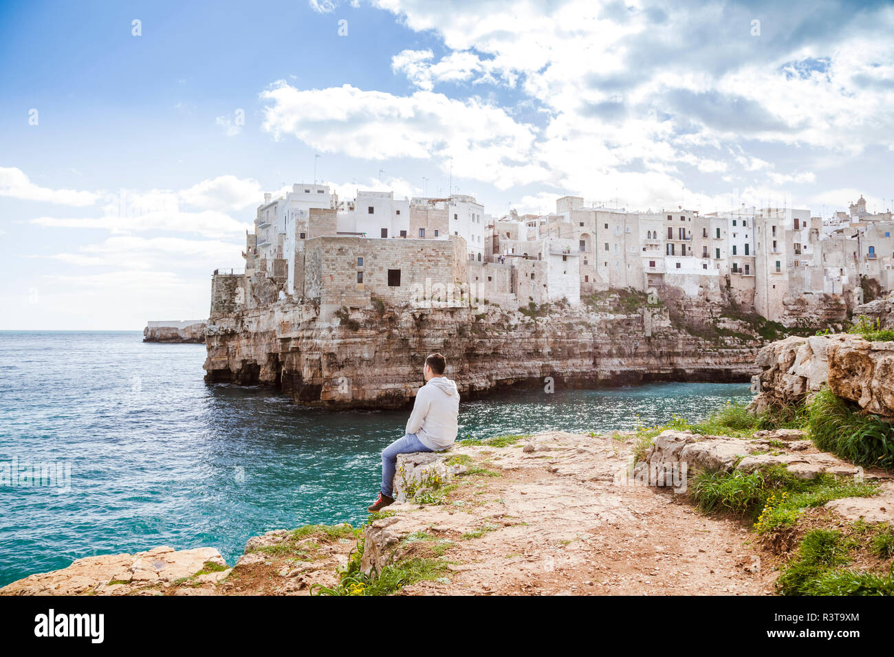 Italien, Apulien, Polognano eine Stute, Rückansicht des Menschen entspannend auf Felsen am Horizont suchen Stockfoto