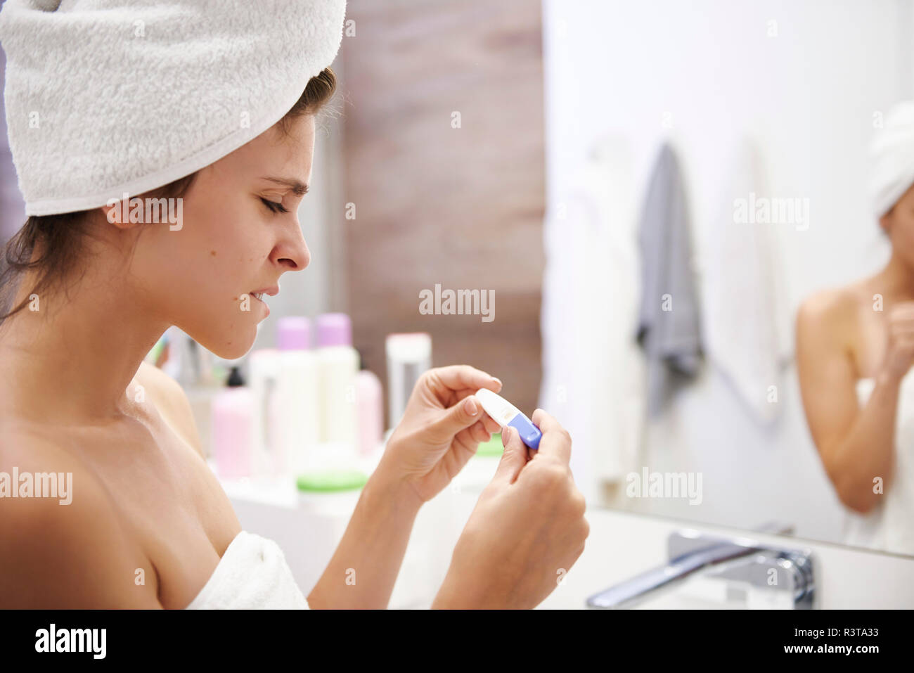Junge Frau im Badezimmer sorgen über Schwangerschaft Test Ergebnis Stockfoto