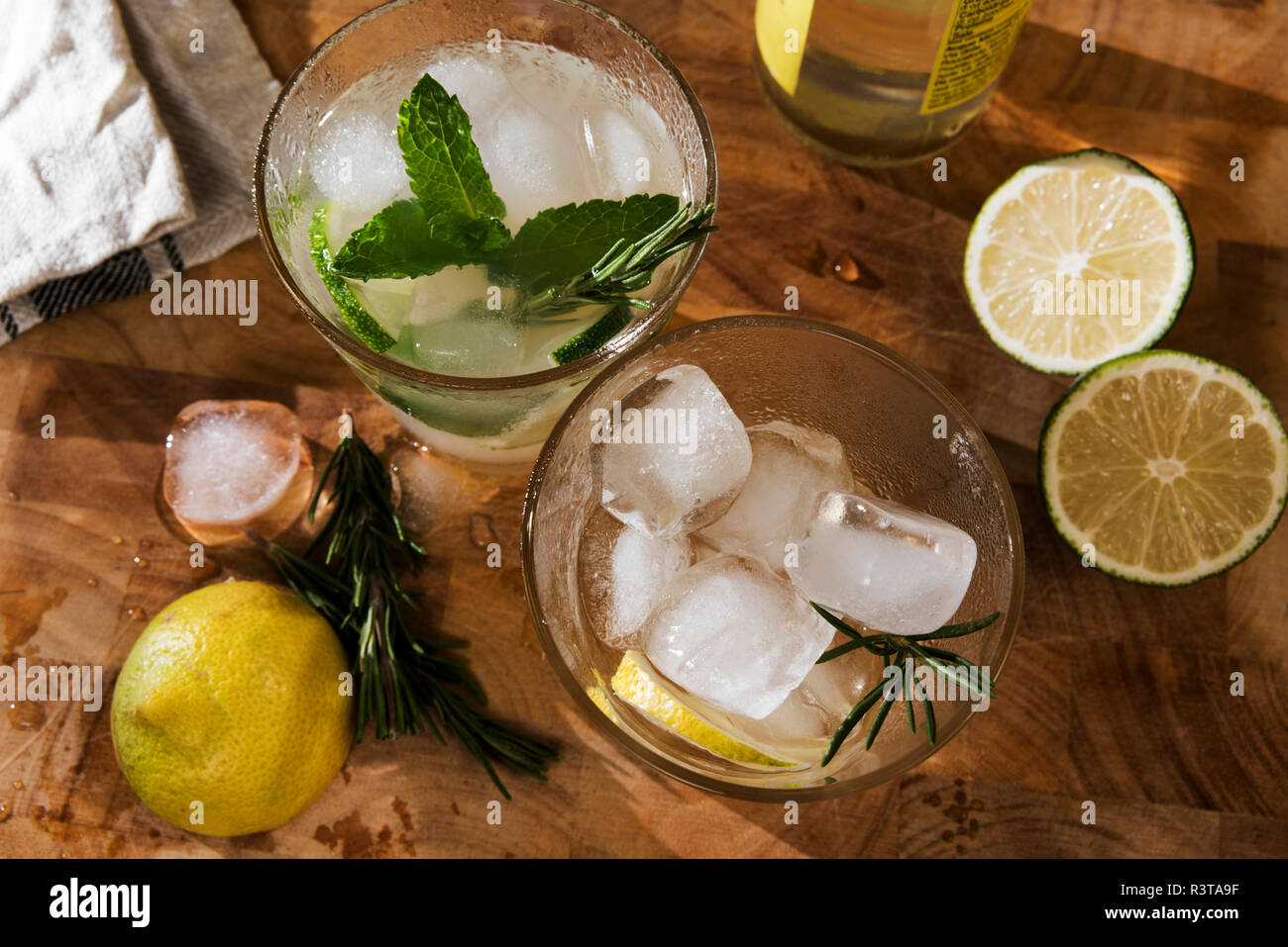 Glas Gin Tonic mit Limette, Minze, Rosmarin und Eis und Zitrone, Rosmarin und Eis Stockfoto