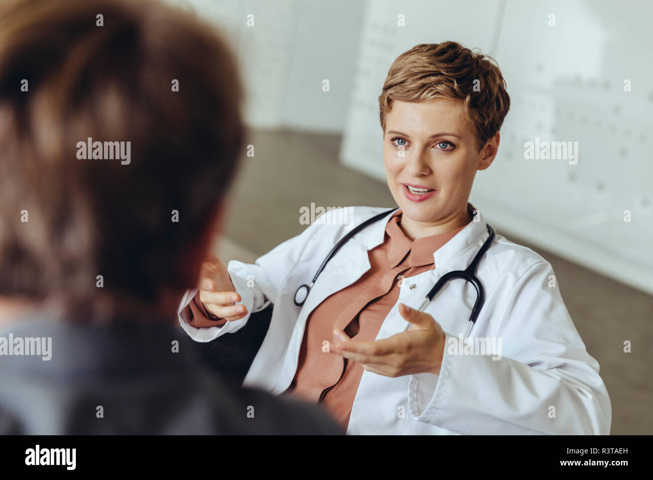 Ärztin im Gespräch mit Patienten in der Praxis Stockfoto