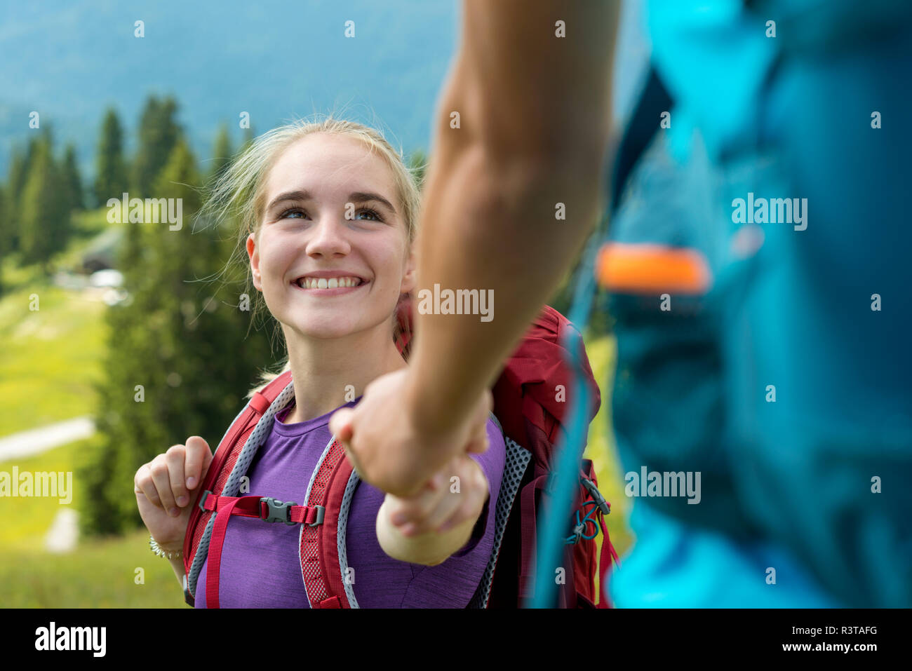 Deutschland, Bayern, in der Nähe von Lenggries, Brauneck glückliche junge Frau Wandern in alpiner Landschaft die Hand des Freundes Stockfoto
