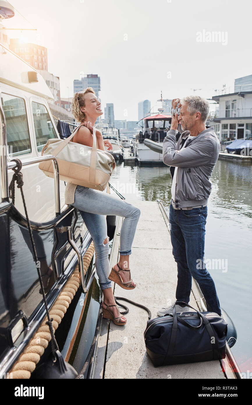 Ältere Menschen nehmen Bild der jungen Frau auf Steg neben Yachtcharter Stockfoto