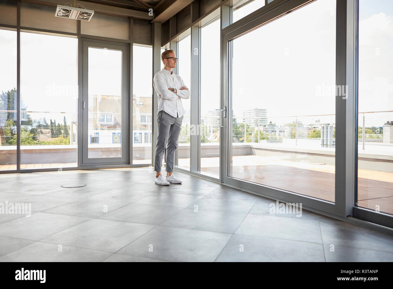 Unternehmer im leeren Raum aus Panorama Fenster Stockfoto