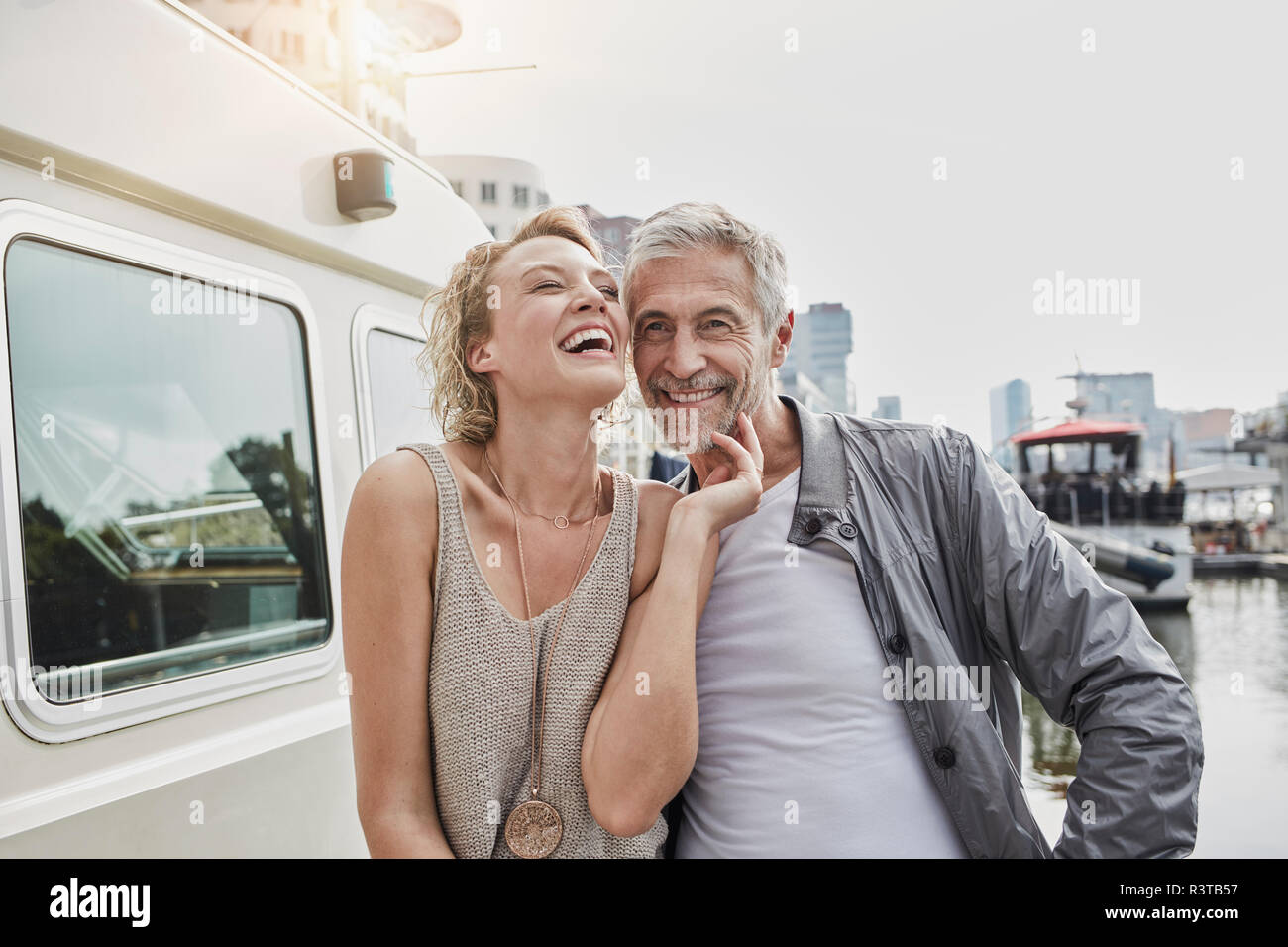 Gerne älterer Mann und junge Frau auf Steg neben Yachtcharter Stockfoto