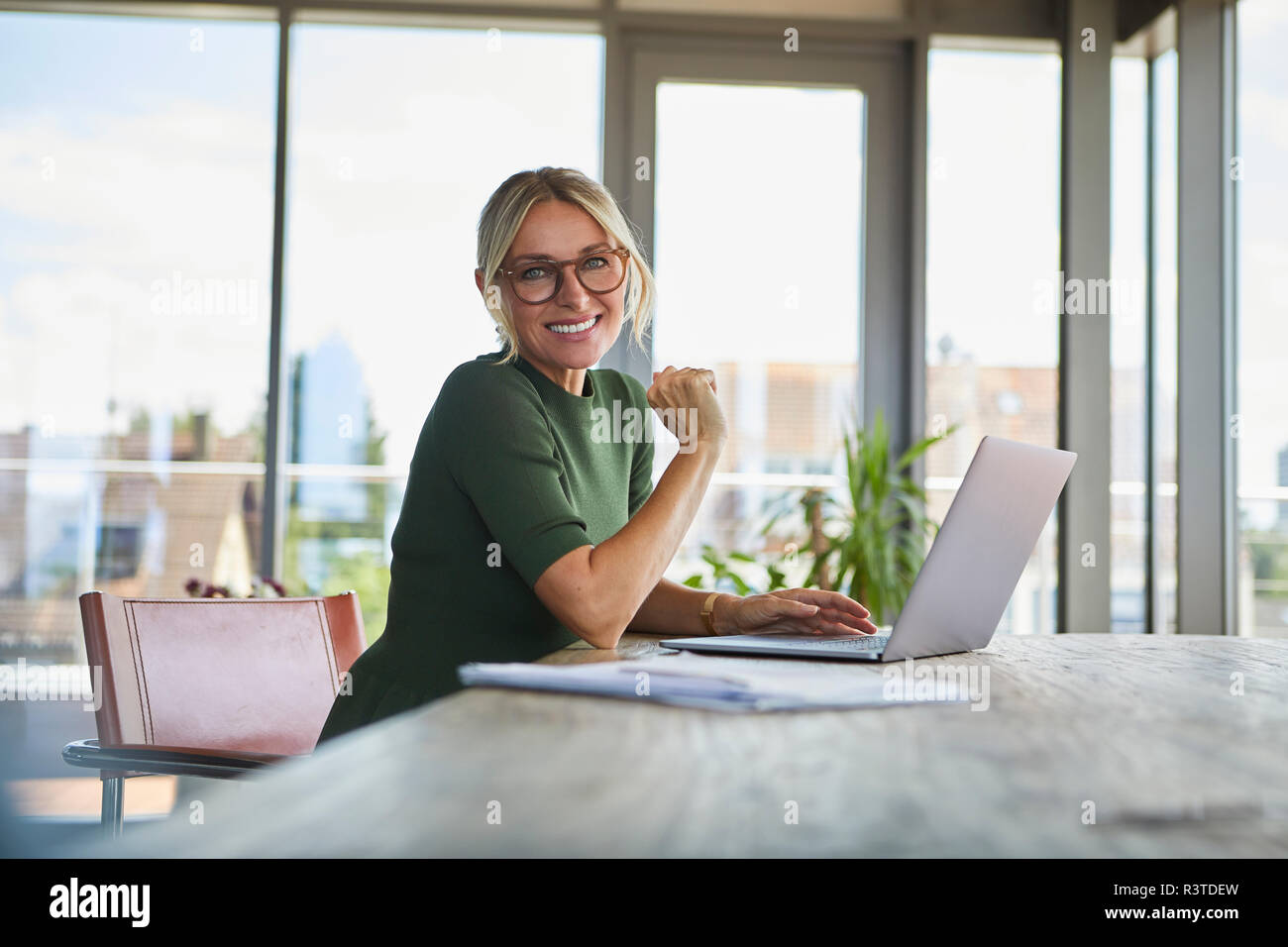 Portrait von lächelnden reife Frau mit Laptop auf dem Tisch zu Hause Stockfoto