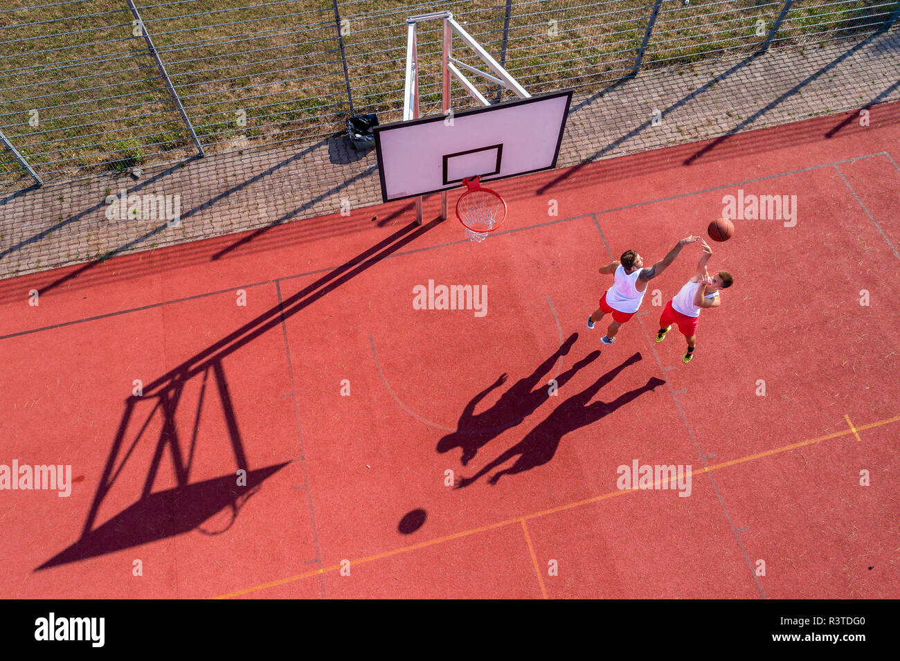 Zwei junge Männer Basketball spielen auf einem außenplatz, Luftaufnahme Stockfoto