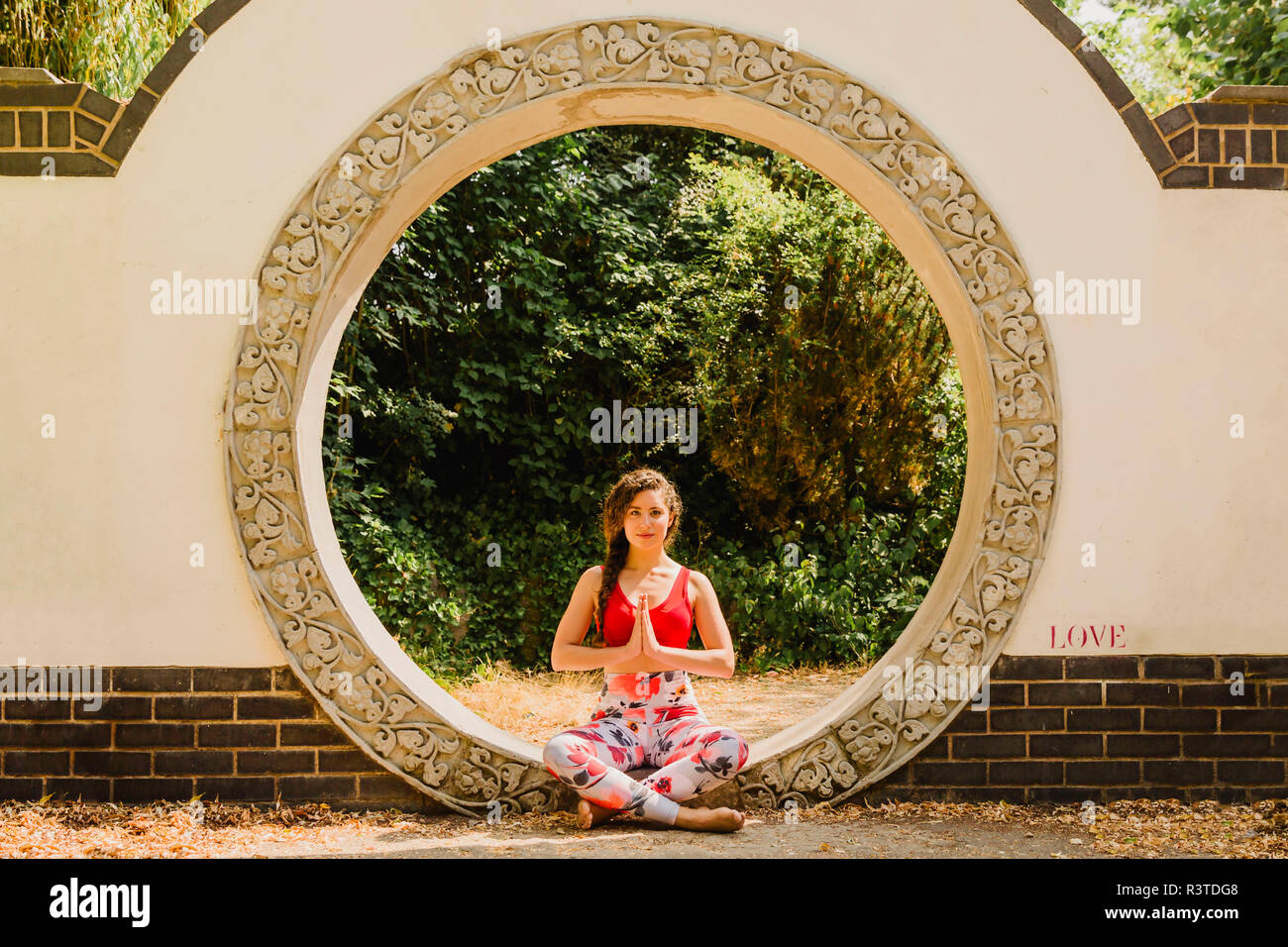 Junge Frau üben Pilates in einem städtischen Park Stockfoto