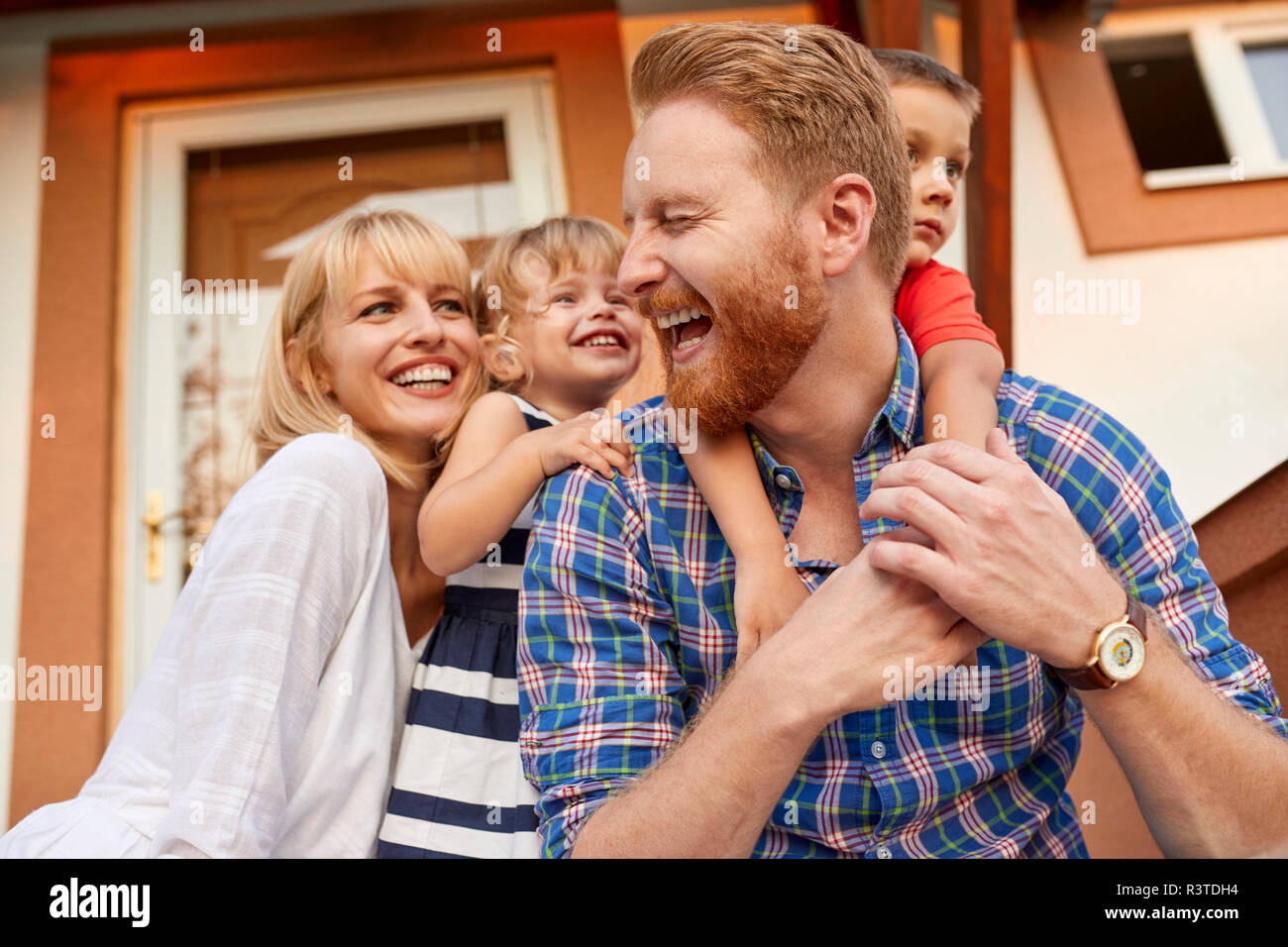 Happy Family auf der Veranda ihres Hauses Stockfoto