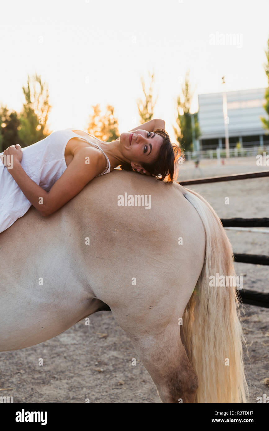 Portrait von Frau entspannend auf dem Pferderücken Stockfoto