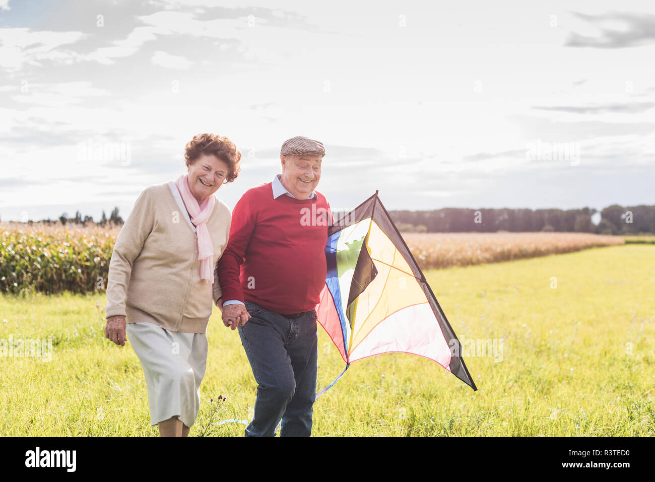 Gerne älteres Paar mit Kite in ländlichen Landschaft Stockfoto