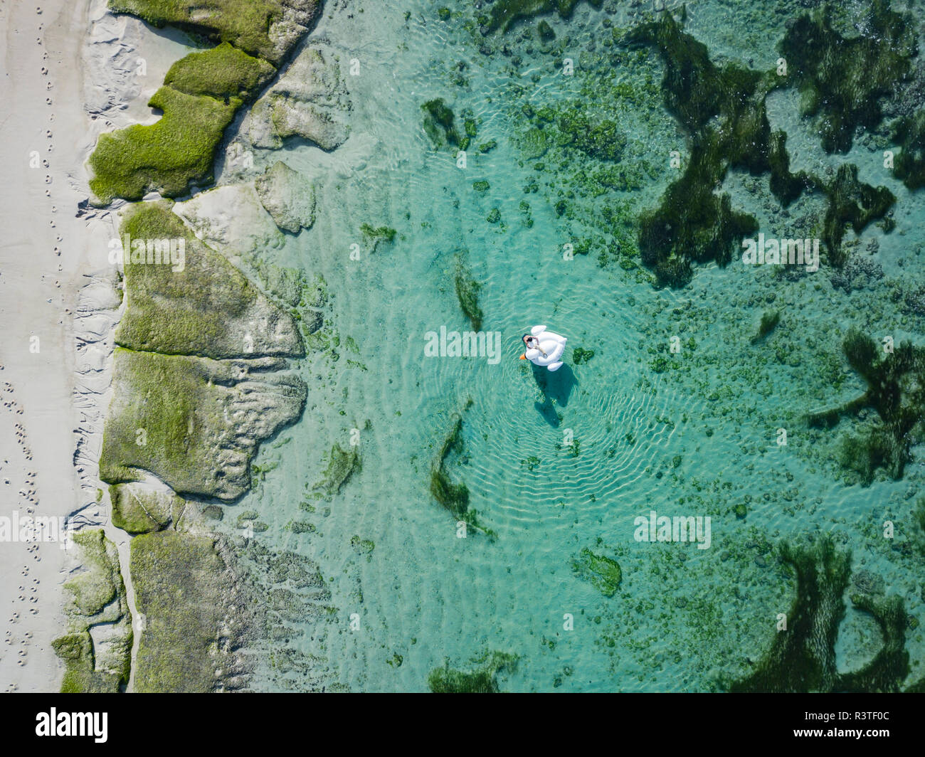 Indonesien, Bali, Luftaufnahme von Karma Kandara Strand, eine Frau, Luftmatratze auf dem Wasser schwimmend Stockfoto