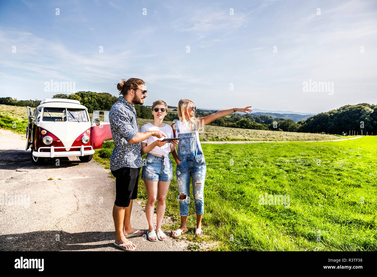 Freunde mit Tablet außerhalb van in ländlichen Landschaft Stockfoto