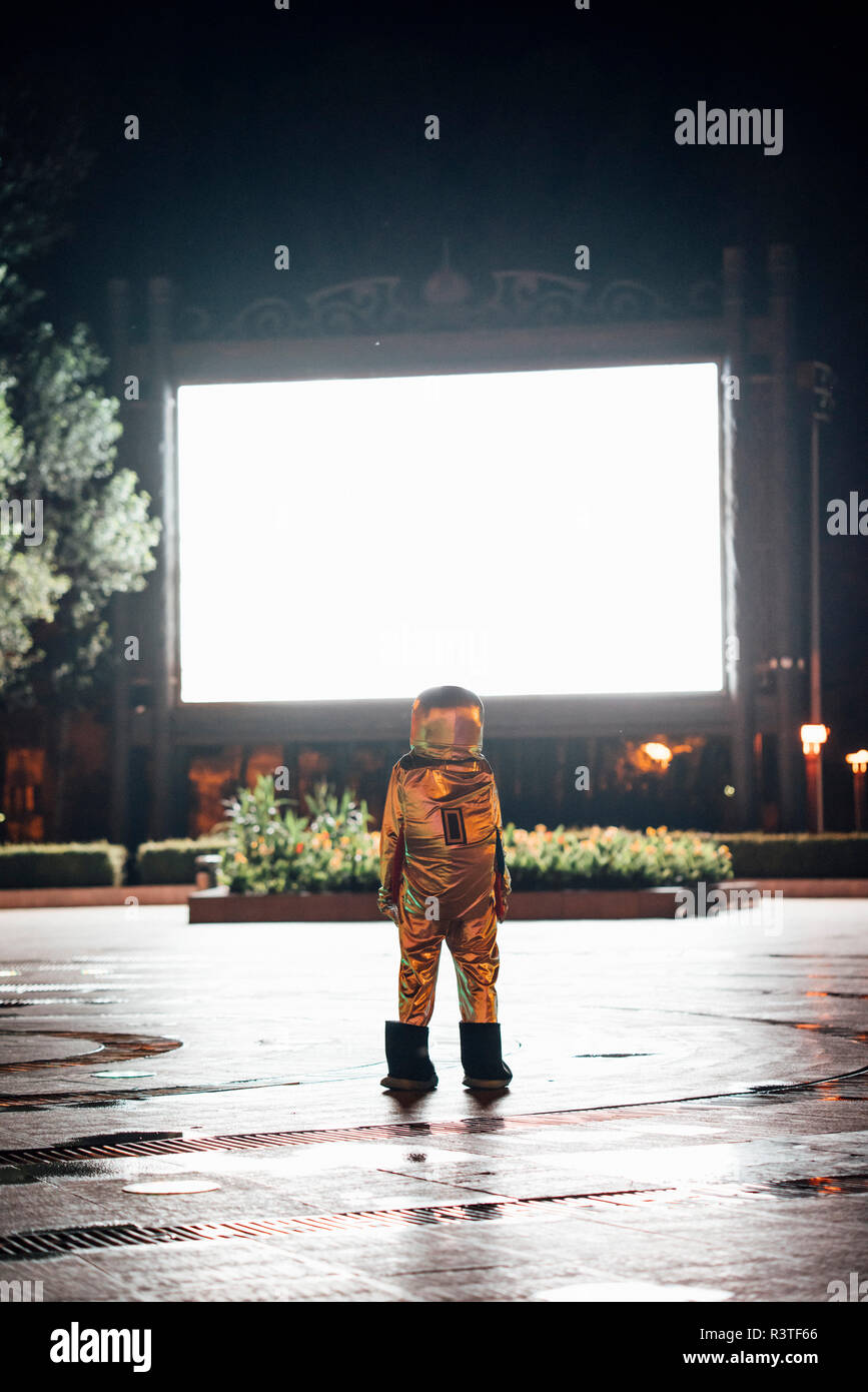 Spaceman auf einem Platz in der Nacht von strahlenden Projektionsfläche angezogen Stockfoto