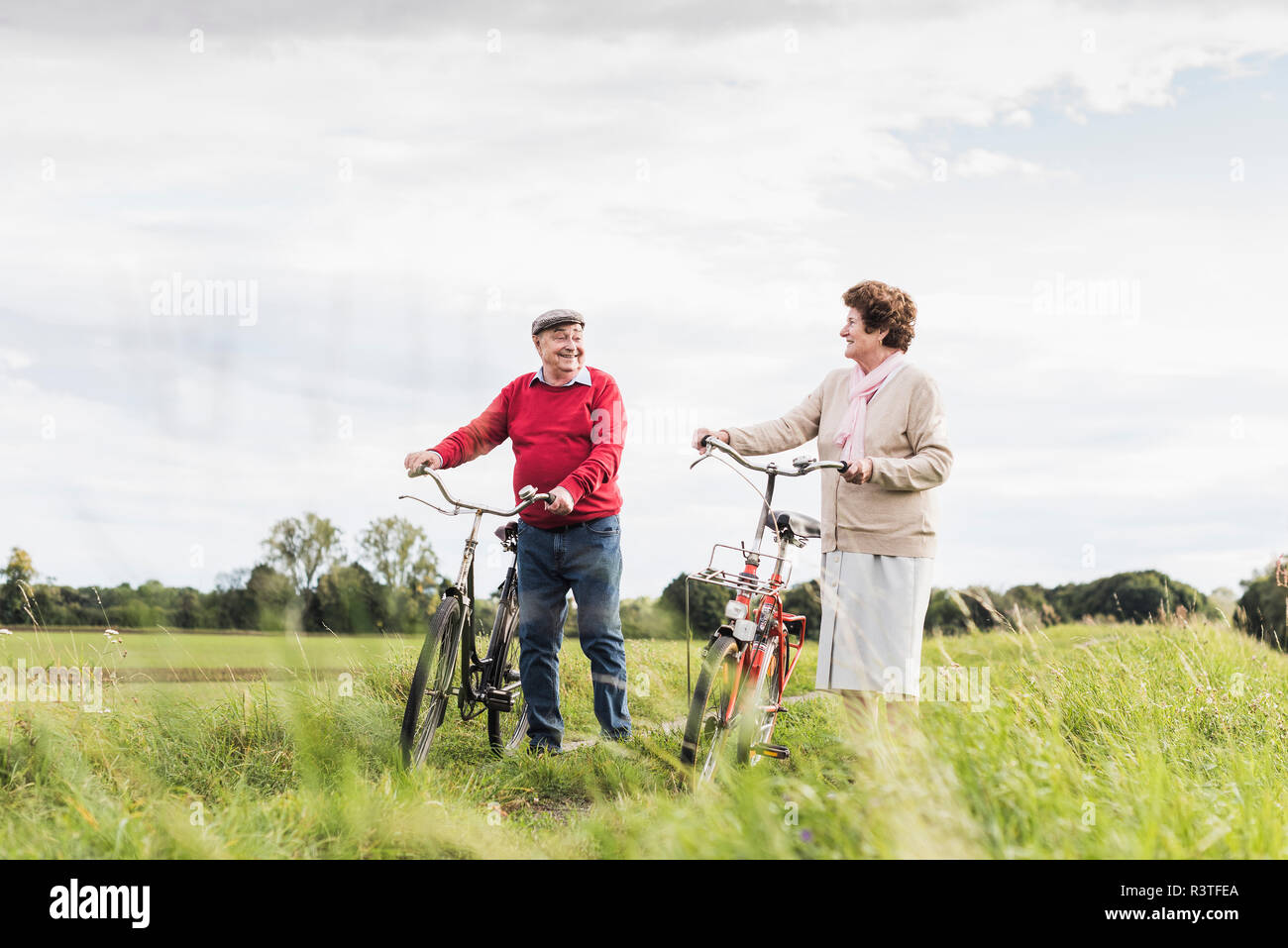 Senior Paar drücken Fahrräder in ländlichen Landschaft Stockfoto