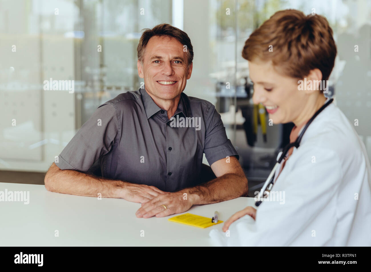 Ärztin im Gespräch mit Patienten in der Praxis Stockfoto