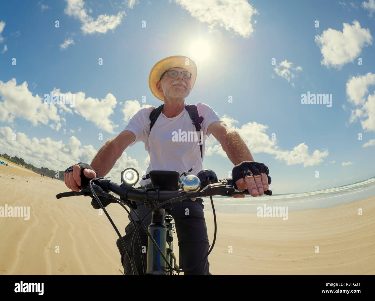 Frankreich, Bretagne, Sainte-Anne la Palud, Plage de Treguer, älterer Mann Riding Mountain e-Bike am Strand Stockfoto