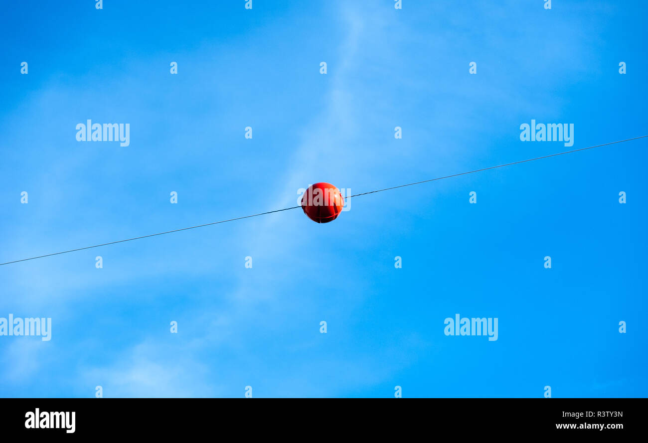 Single orange Kugel auf Kabel gegen Sky Stockfoto