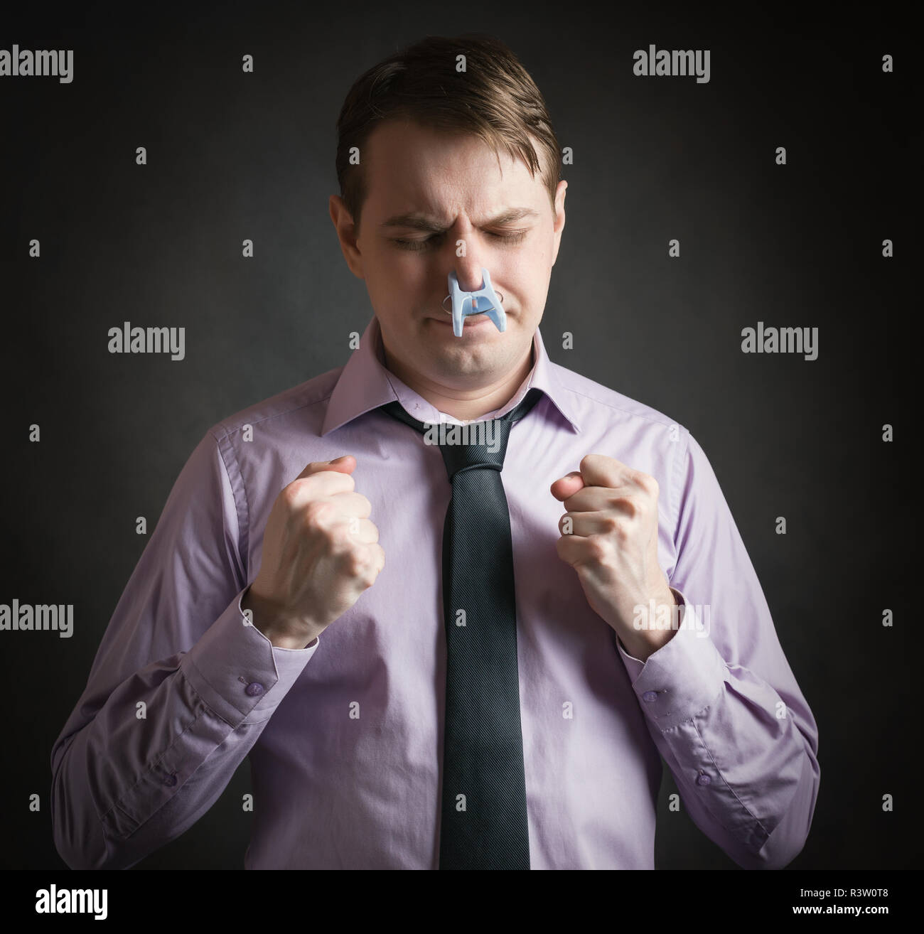 Portrait der junge Geschäftsmann Mann mit Wäscheklammer auf der Nase - schlechter Geruch Konzept Fotografie. Stockfoto