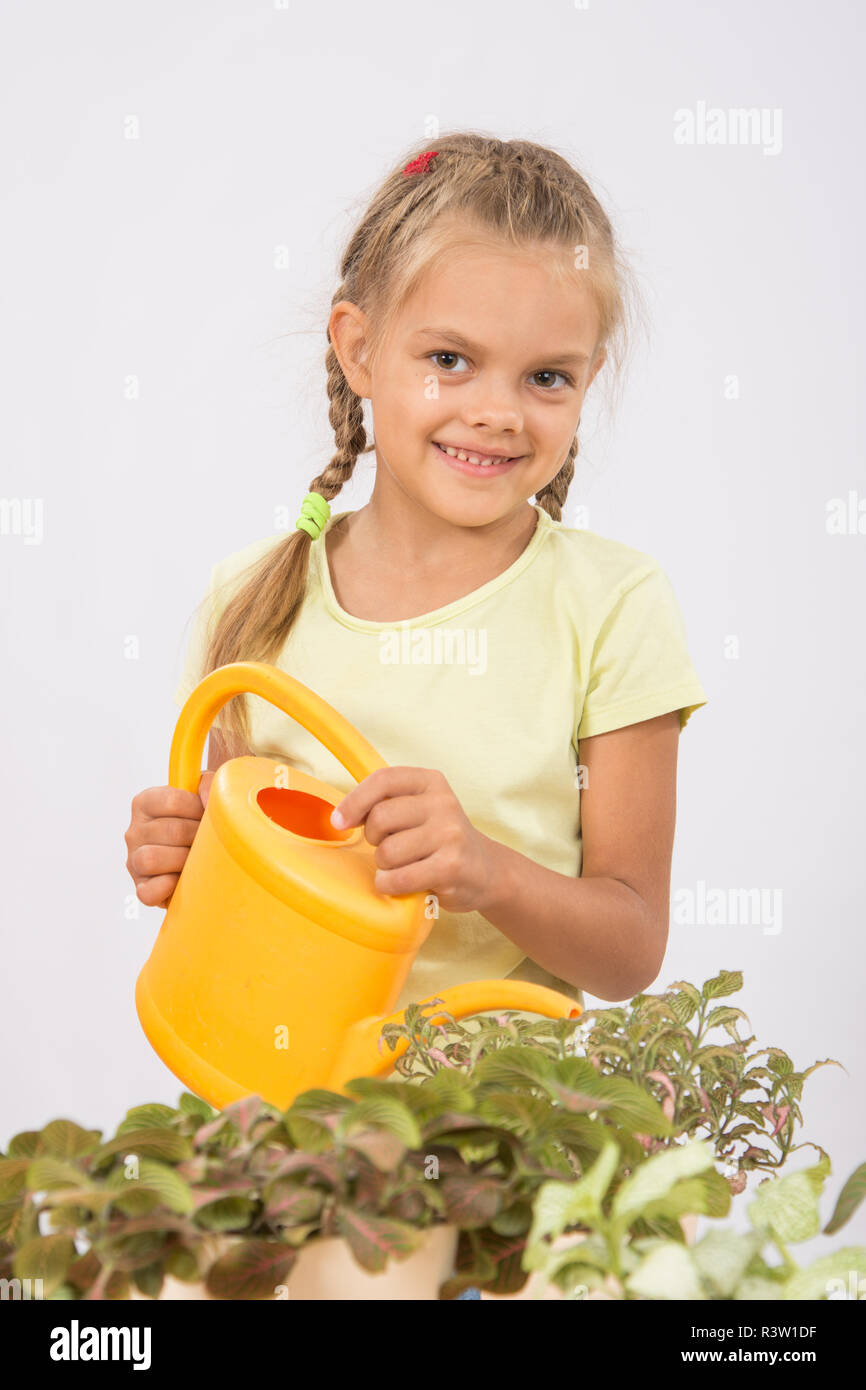 Gerne kleine Mädchen Blumen gießen Gießen Stockfoto