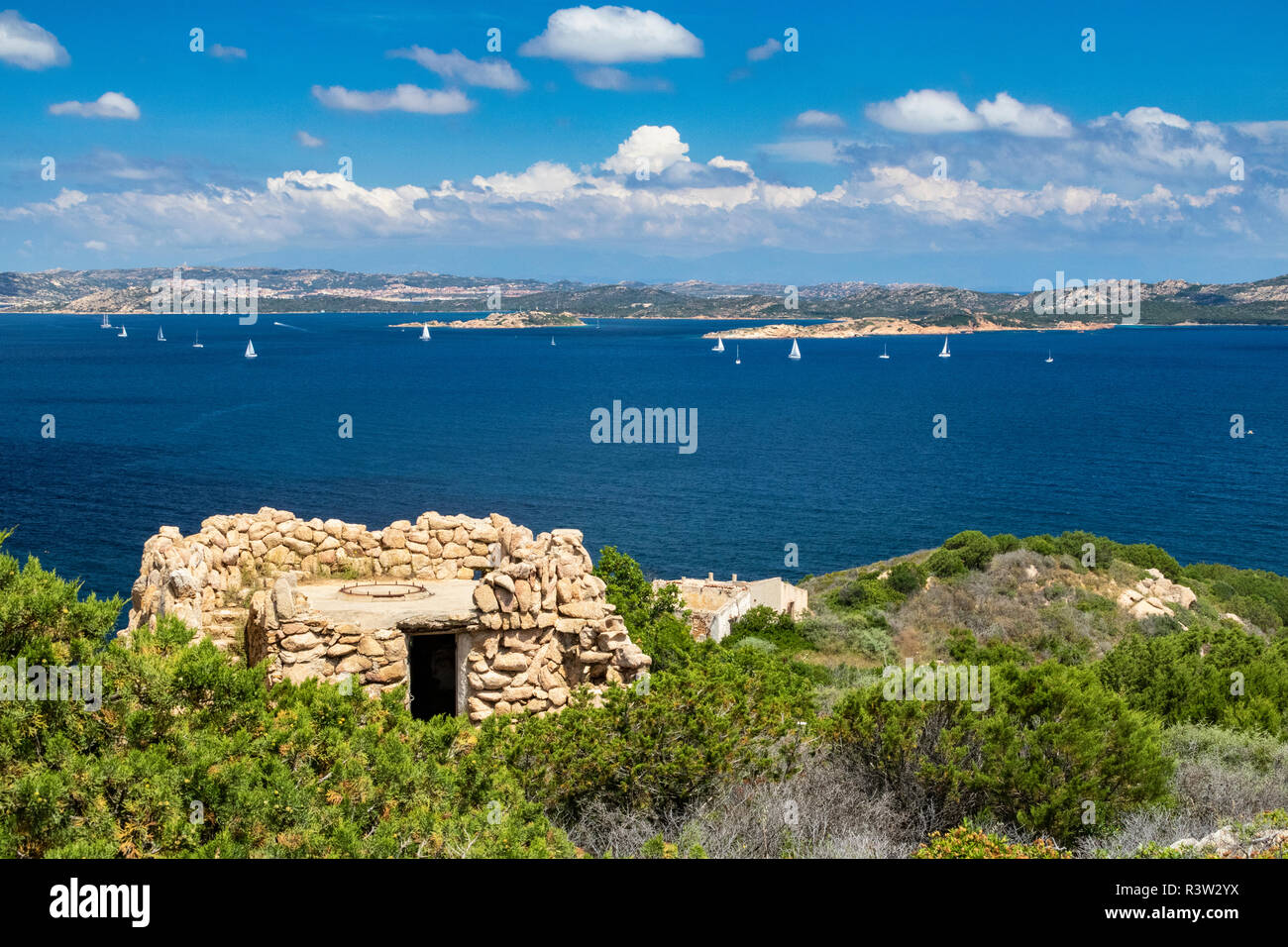 Bunte Granit Küste, Militär, Ruinen, Isola Caprera und La Maddalena mit blauem Himmel und Yachten - Baia Sardinia, Costa Smeralda, Sardinien, Italien. Stockfoto