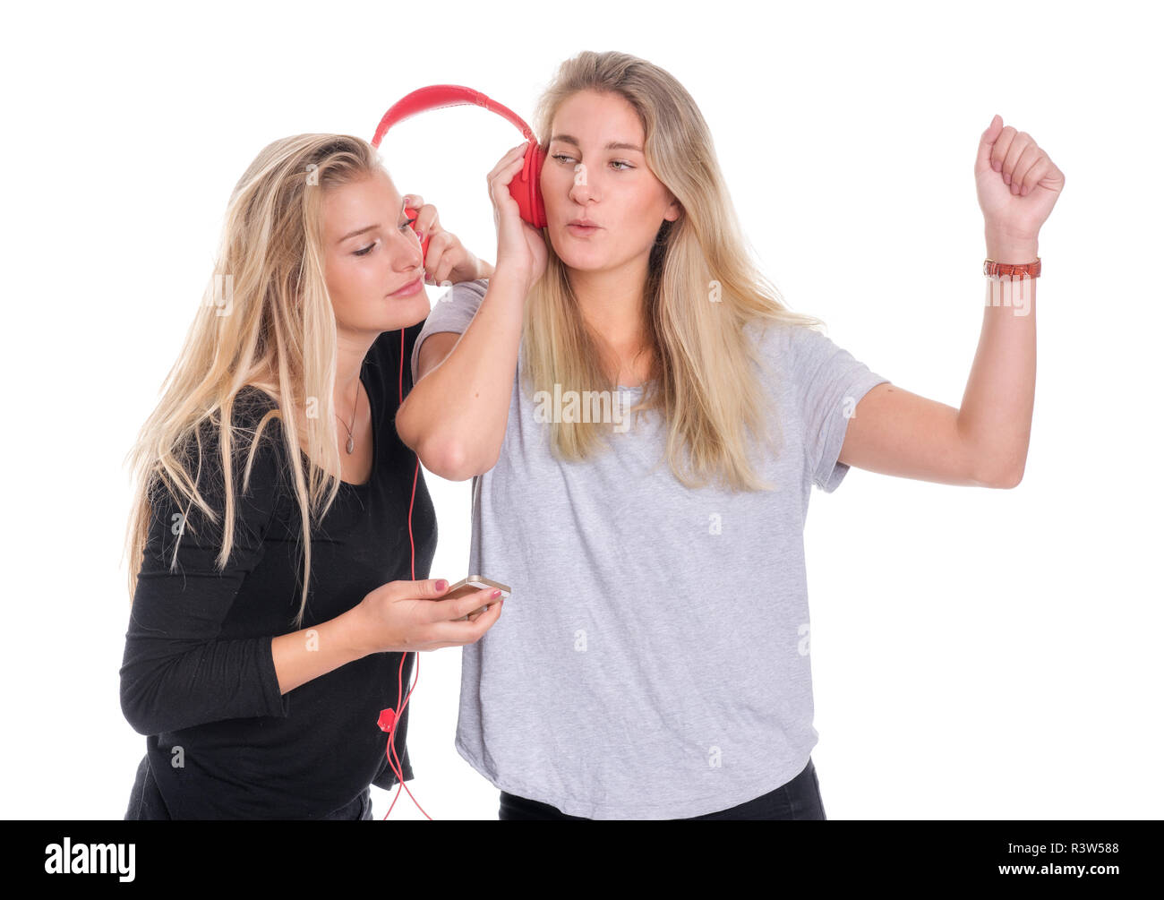 Zwei blonde Frauen zusammen Musik hören über Kopfhörer Stockfoto