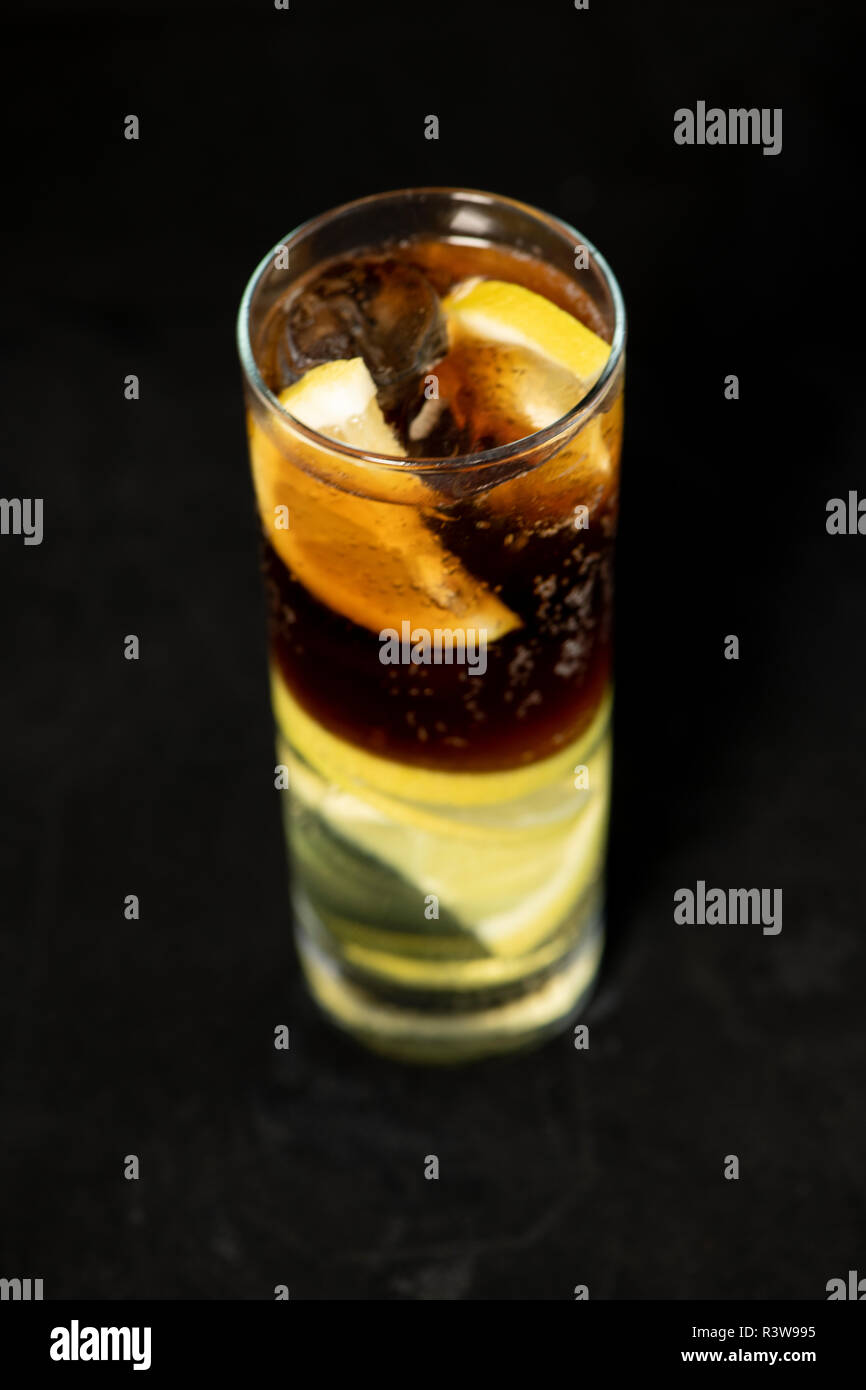 Cuba Libre Cocktail mit Rum, Cola und Limettensaft mit Kalk Keil und voll von Ices mit isolierten schwarzen Hintergrund Stockfoto