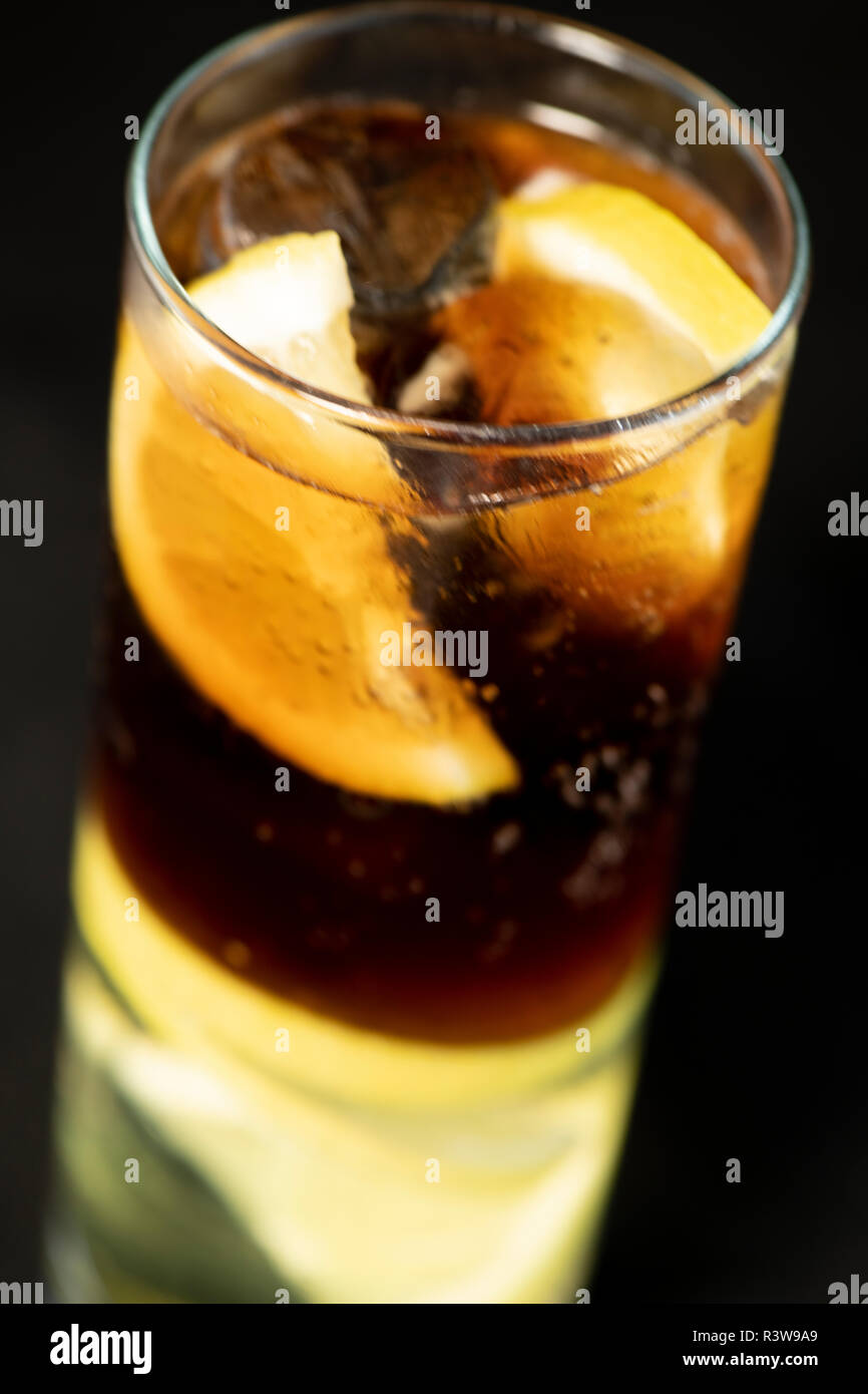 Cuba Libre Cocktail mit Rum, Cola und Limettensaft mit Kalk Keil und voll von Ices mit isolierten schwarzen Hintergrund Stockfoto