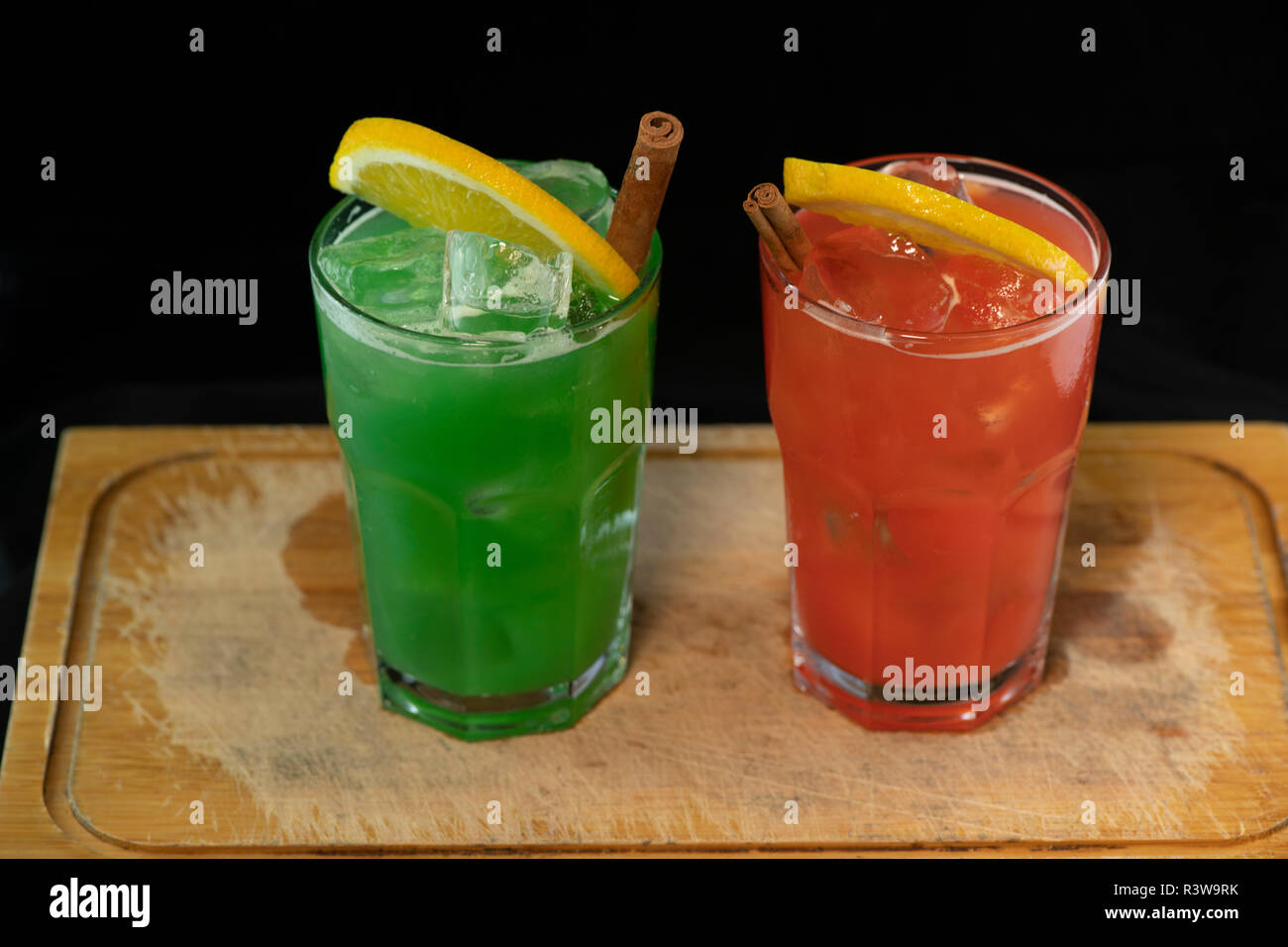 Rote und Grüne Cocktails mit roten und grünen Säfte, Alkohol und Kalk Keil mit isolierten schwarzen Hintergrund Stockfoto