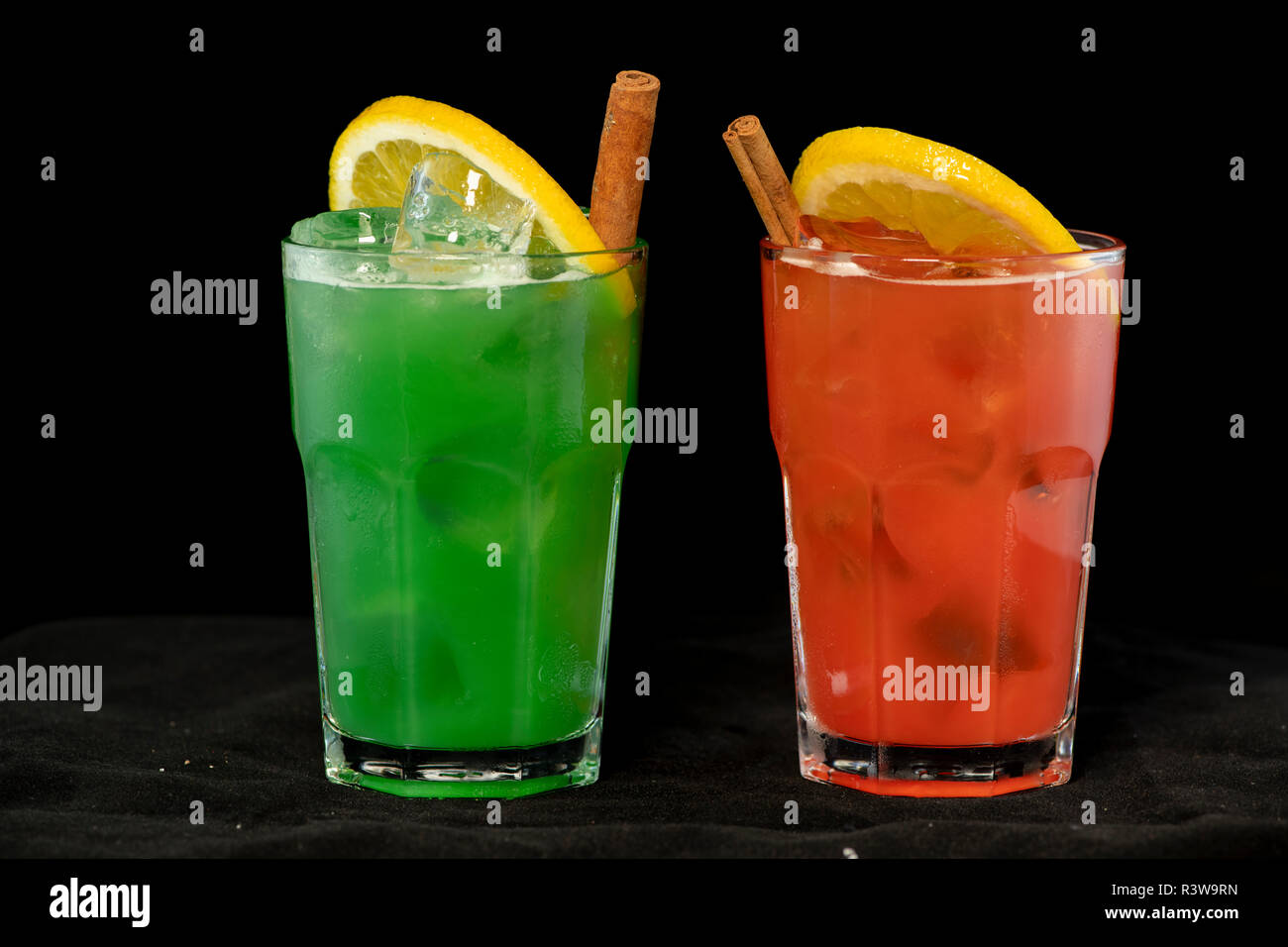 Rote und Grüne Cocktails mit roten und grünen Säfte, Alkohol und Kalk Keil mit isolierten schwarzen Hintergrund Stockfoto