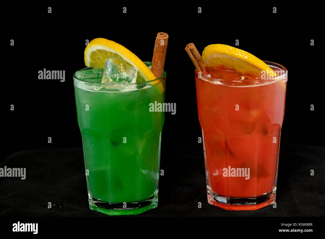 Rote und Grüne Cocktails mit roten und grünen Säfte, Alkohol und Kalk Keil mit isolierten schwarzen Hintergrund Stockfoto