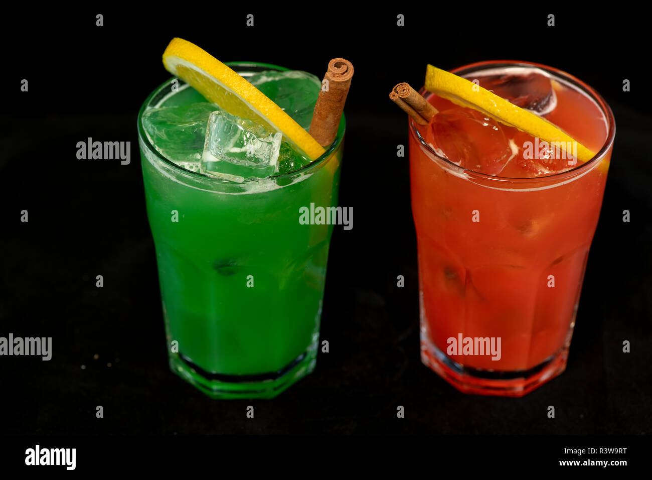 Rote und Grüne Cocktails mit roten und grünen Säfte, Alkohol und Kalk Keil mit isolierten schwarzen Hintergrund Stockfoto