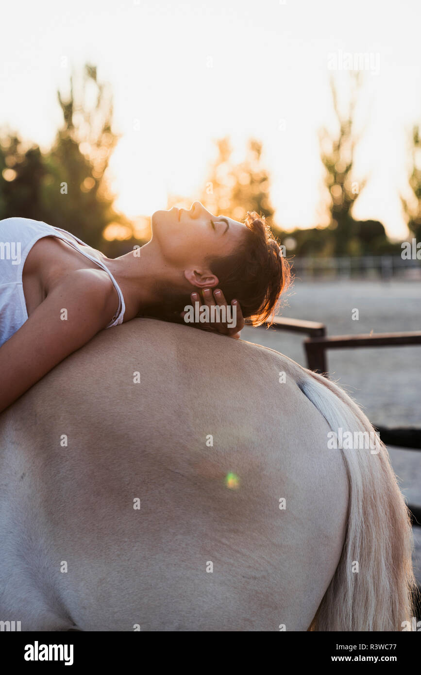 Frau entspannend auf dem Pferderücken Stockfoto