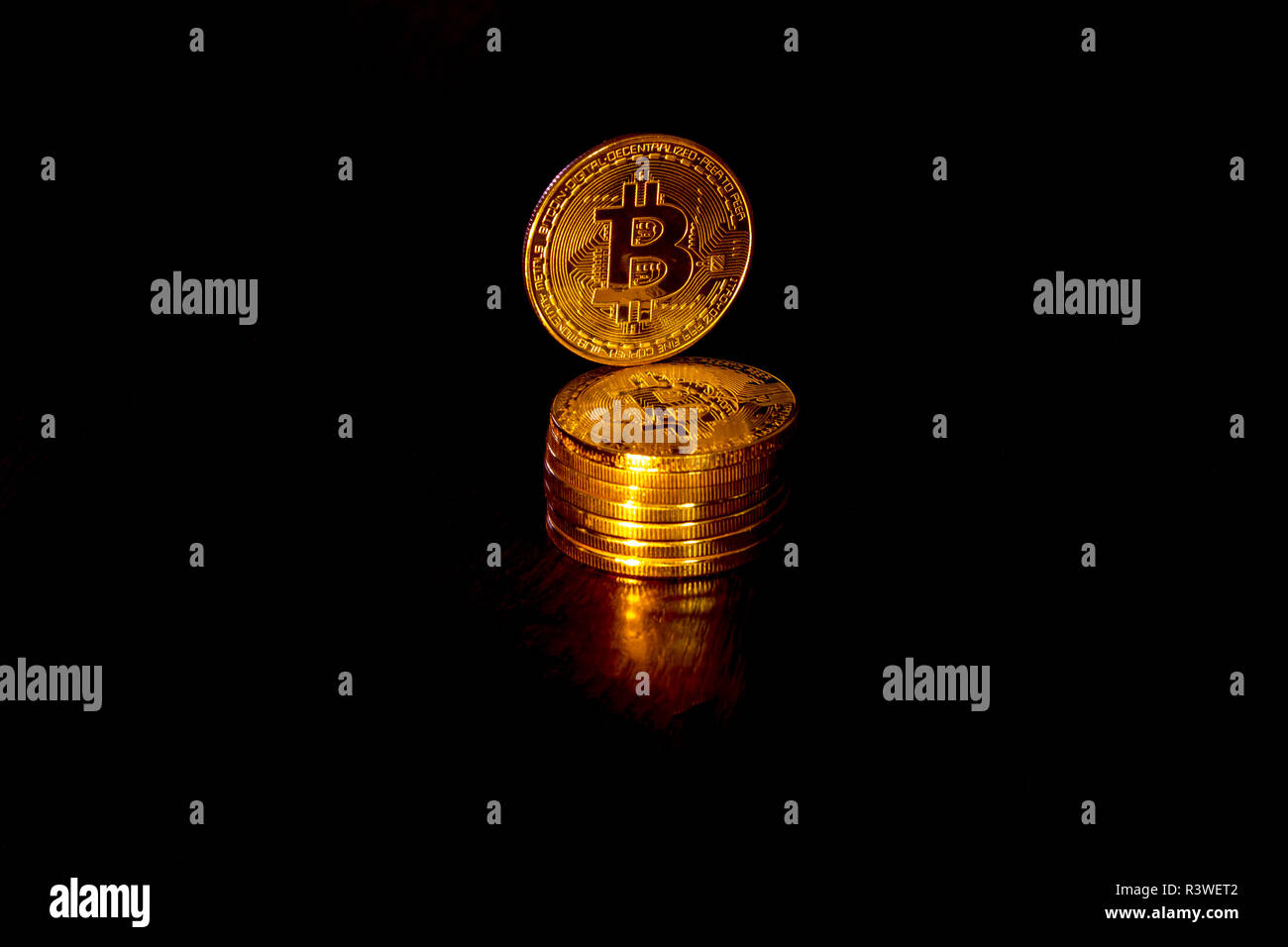 Crypto Währung bitcoin Goldmünzen auf schwarzem Hintergrund. Zusätzlich zu den liegenden Münzen, es gibt ständige Bitcoin. Stockfoto