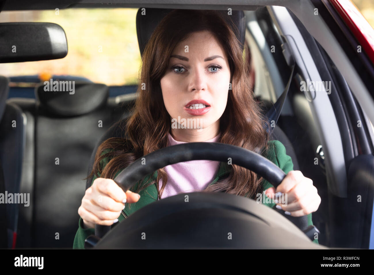 Portrait einer jungen Frau schockiert Auto Stockfoto