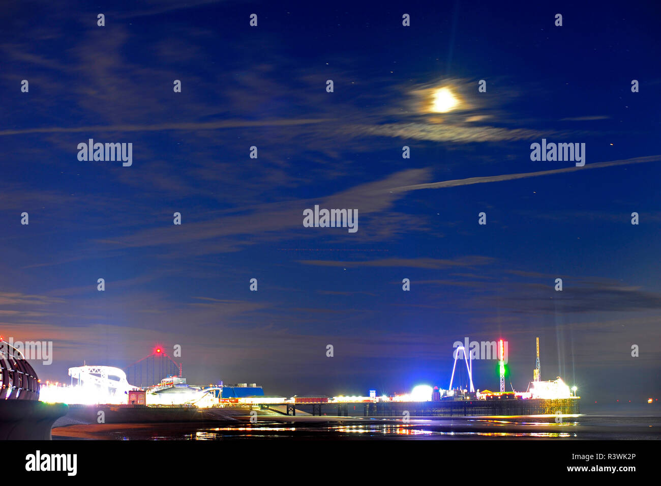 Mond und Stern trails bei Ebbe über ein hell South Pier in Blackpool Illuminations lit Stockfoto