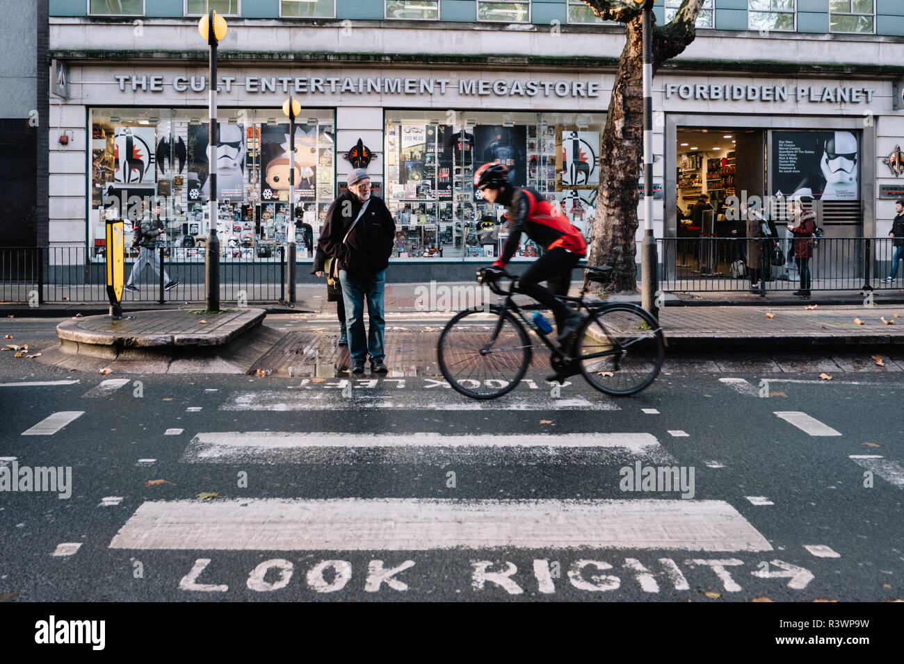 Farbe Bild von Zebrastreifen außerhalb Forbidden Planet shop in London mit einem Radfahrer und einem Fußgänger. Stockfoto
