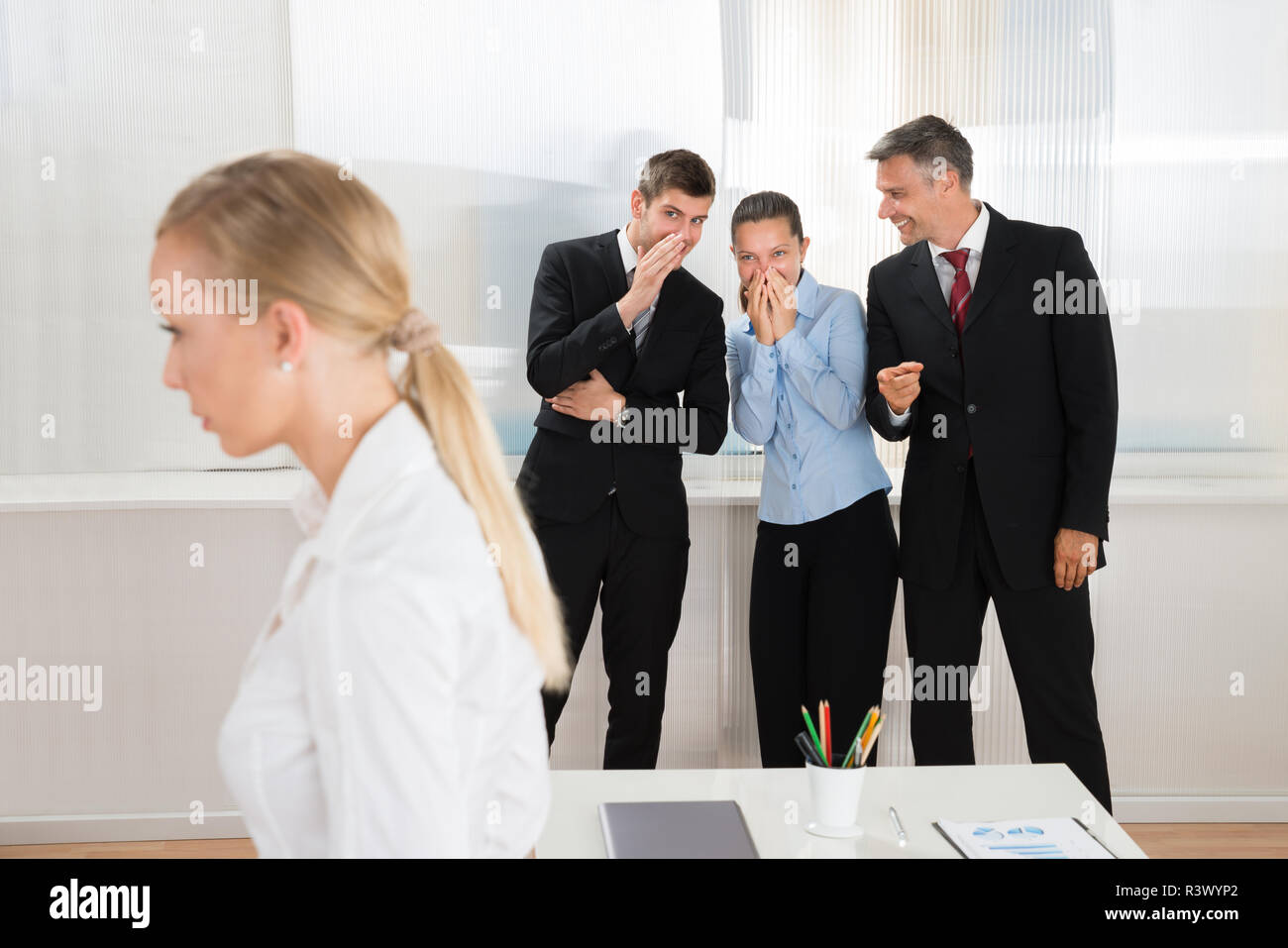 Geschäftsleute flüsternd über Frau Stockfoto