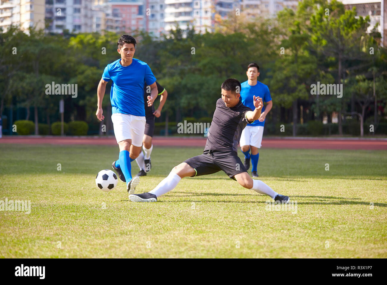 Eine Gruppe von jungen asiatischen Fußball-Fußball-Spieler spielt auf im Hof. Stockfoto