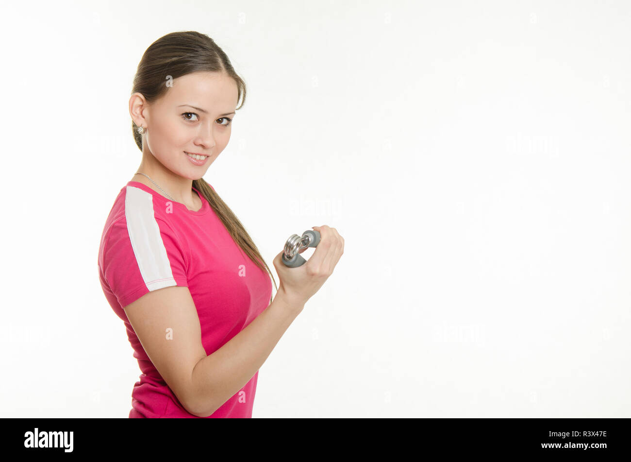 Schönen weiblichen Athleten flexing Muskeln der Hand Expander Stockfoto