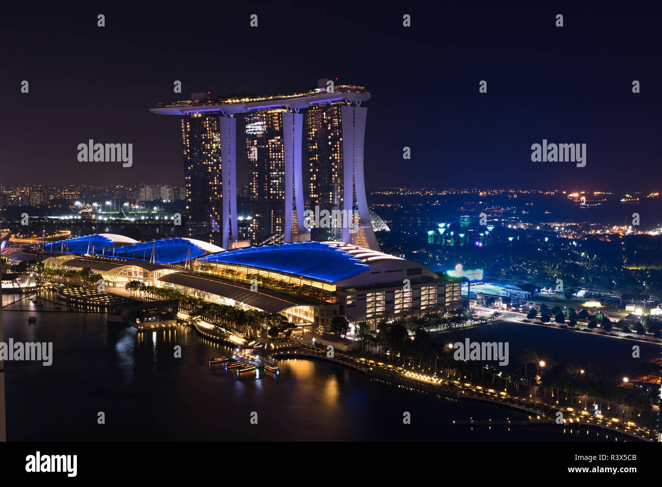 Singapur - 6. Juni 2017: Marina Bay Sands Hotel und die Shoppes Einkaufszentrum an der Marina Bay mit Menschen auf dem Damm bei Nacht, hohe Angl Stockfoto