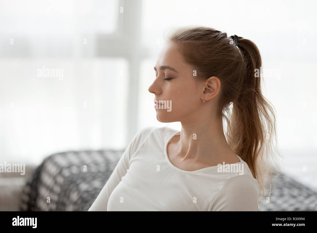 Ruhig Mädchen mit geschlossenen Augen meditieren zu Hause Stockfoto