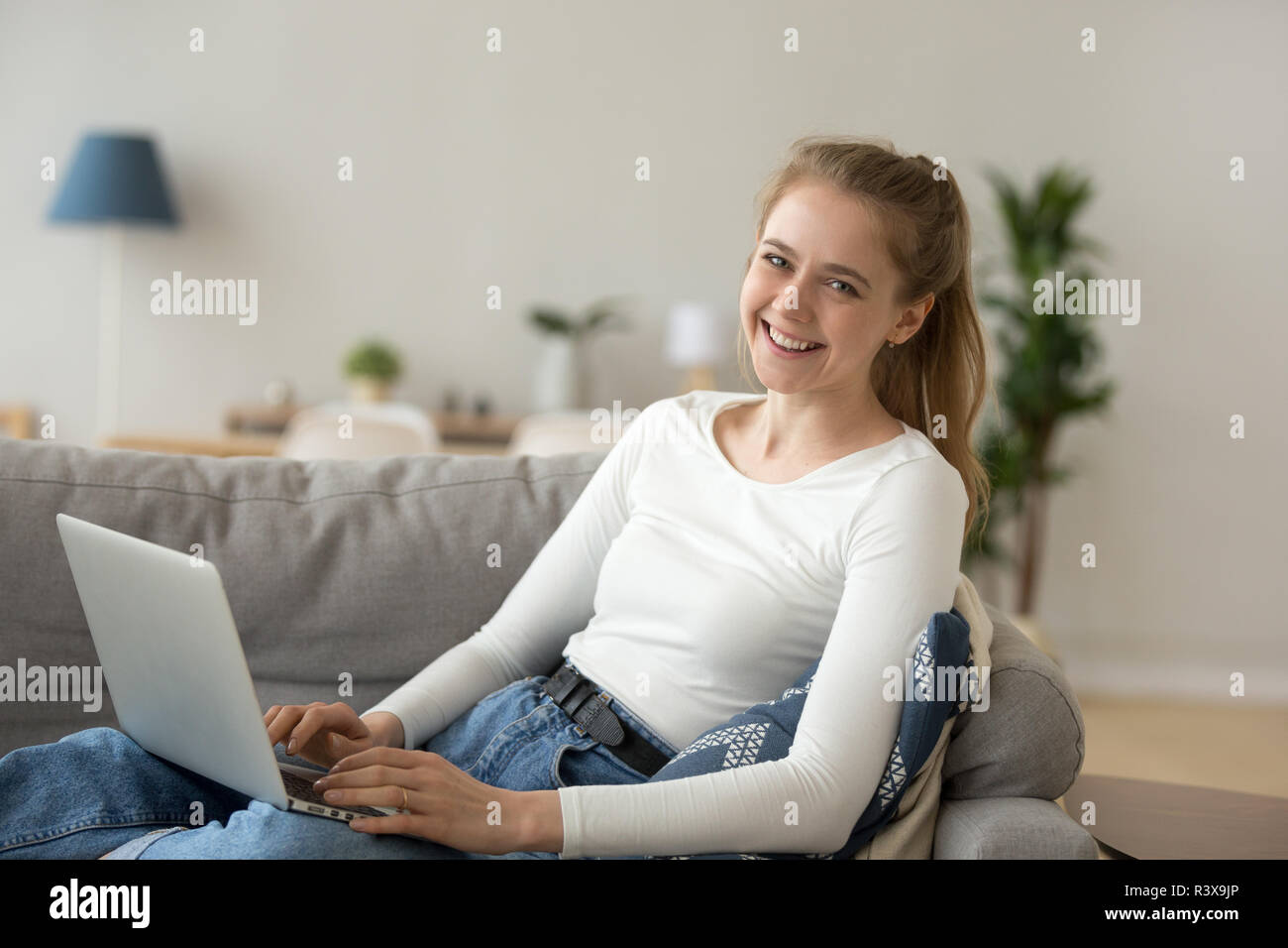 Portrait von lächelnden jungen Frau auf dem Laptop zu Hause arbeiten Stockfoto