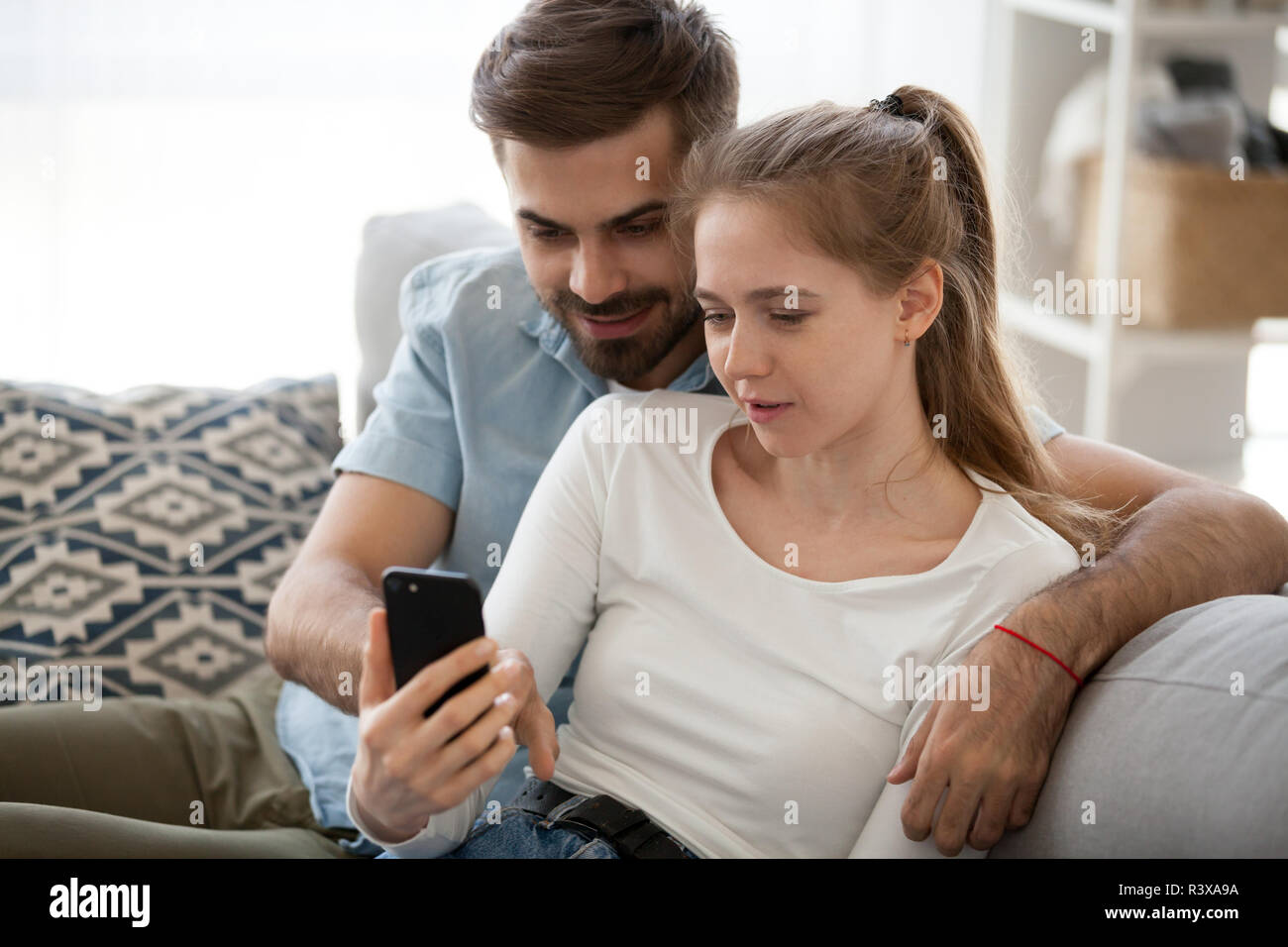 Tausendjährige Paar auf dem Behandlungstisch mit Smartphone Entspannen Stockfoto