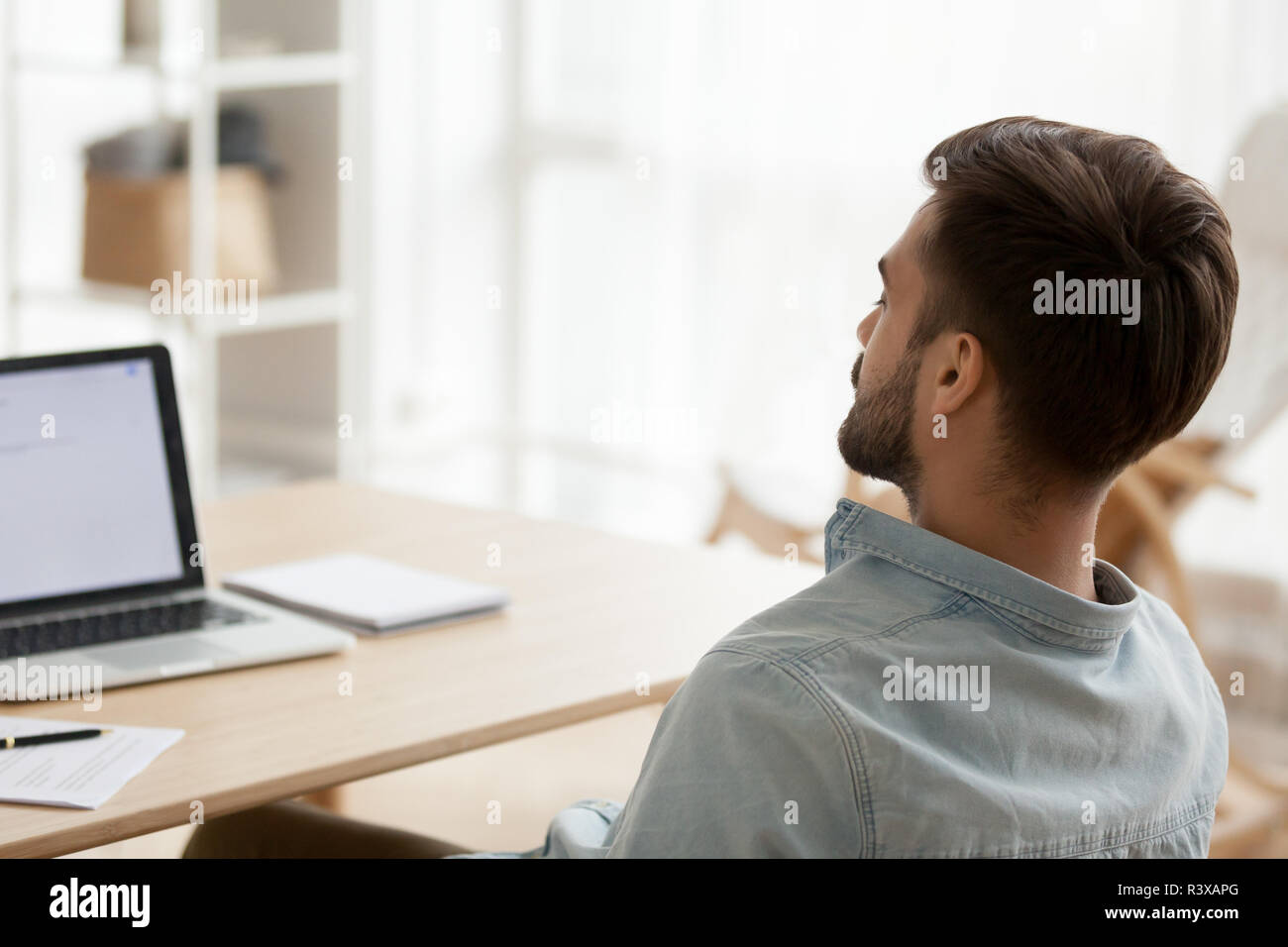 Rückansicht der müde Mann Einschlafen am Arbeitsplatz Stockfoto