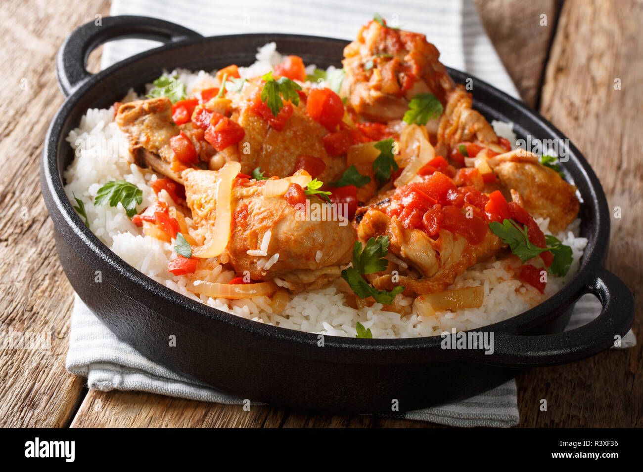 Haitianische Rezept für pikante Huhn in Sauce Gemüse mit Weißwein mit weißer Reis in einer Pfanne Nahaufnahme auf dem Tisch gekocht. Horizontale Stockfoto