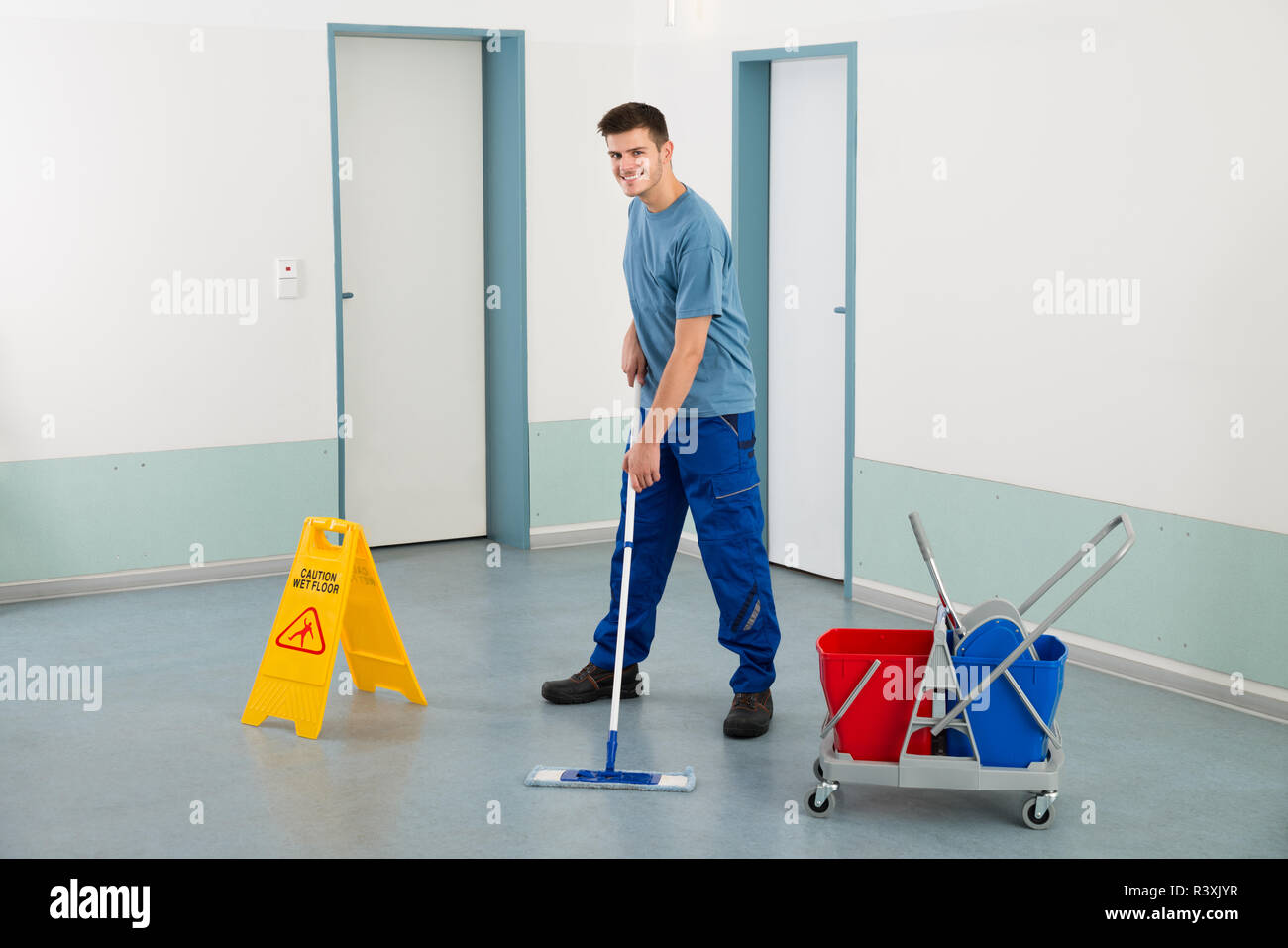 Männliche Arbeiter mit der Reinigung der Geräte Boden wischen  Stockfotografie - Alamy