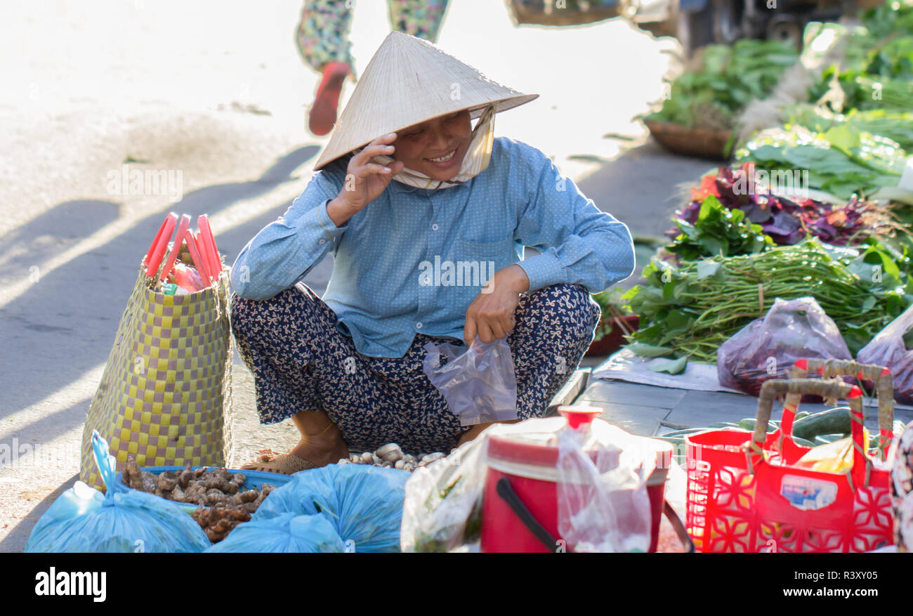 Vietnamesin in konischer Hut shopping frische Lebensmittel, Hoi An, Vietnam. Stockfoto