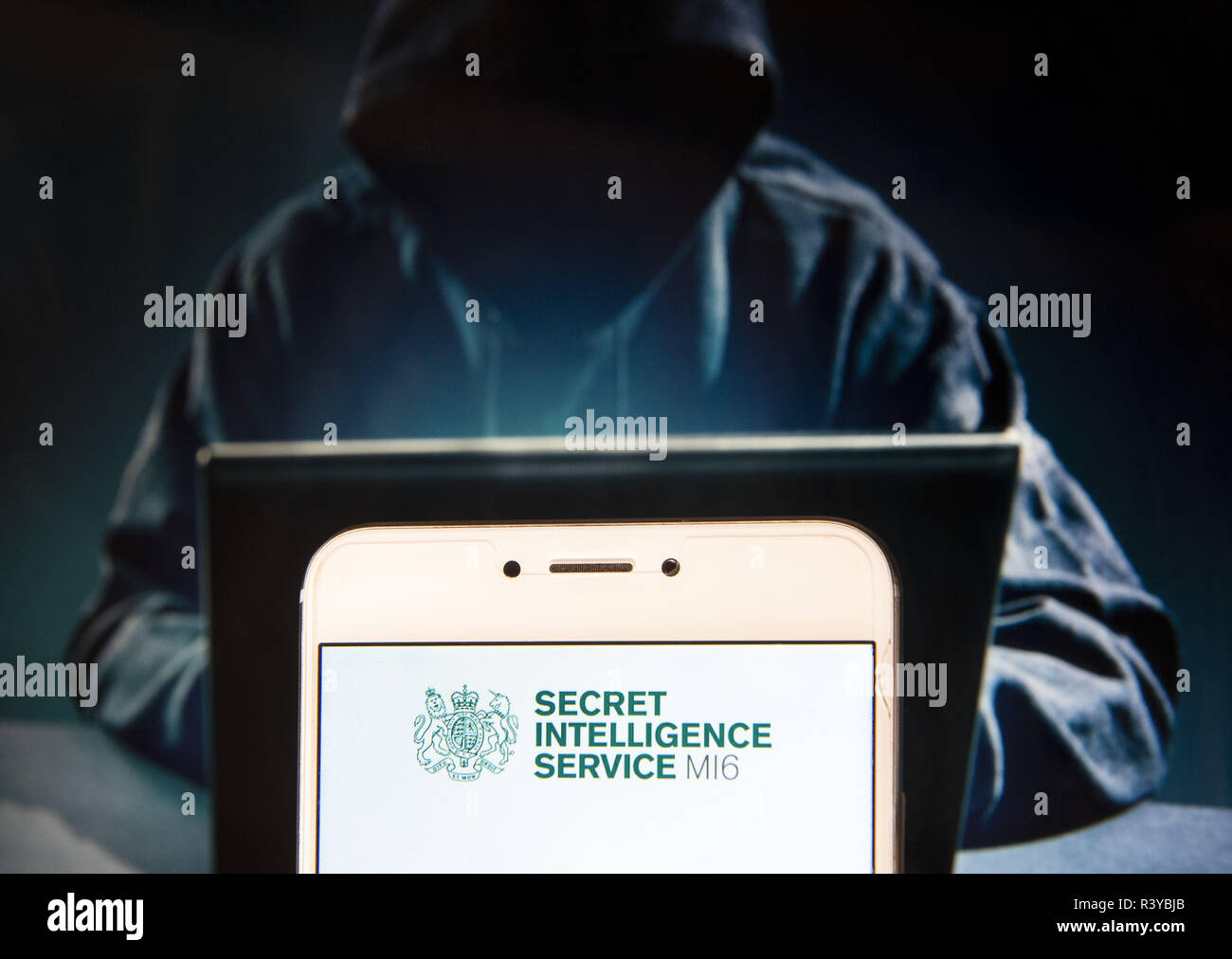 Hong Kong. 23 Nov, 2018. Die britischen Secret Intelligence Service (SIS) auch bekannt als MI6-Logo ist auf ein Android mobile Gerät mit einer Abbildung der Hacker im Hintergrund zu sehen. Credit: Miguel Candela/SOPA Images/ZUMA Draht/Alamy leben Nachrichten Stockfoto